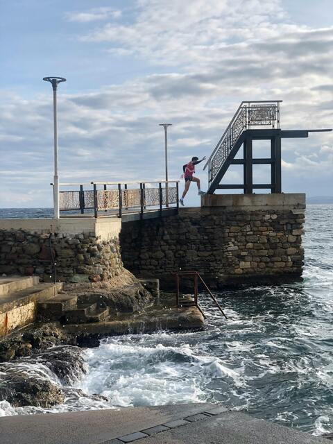 Runner Jumping on Coastal Stone Pier