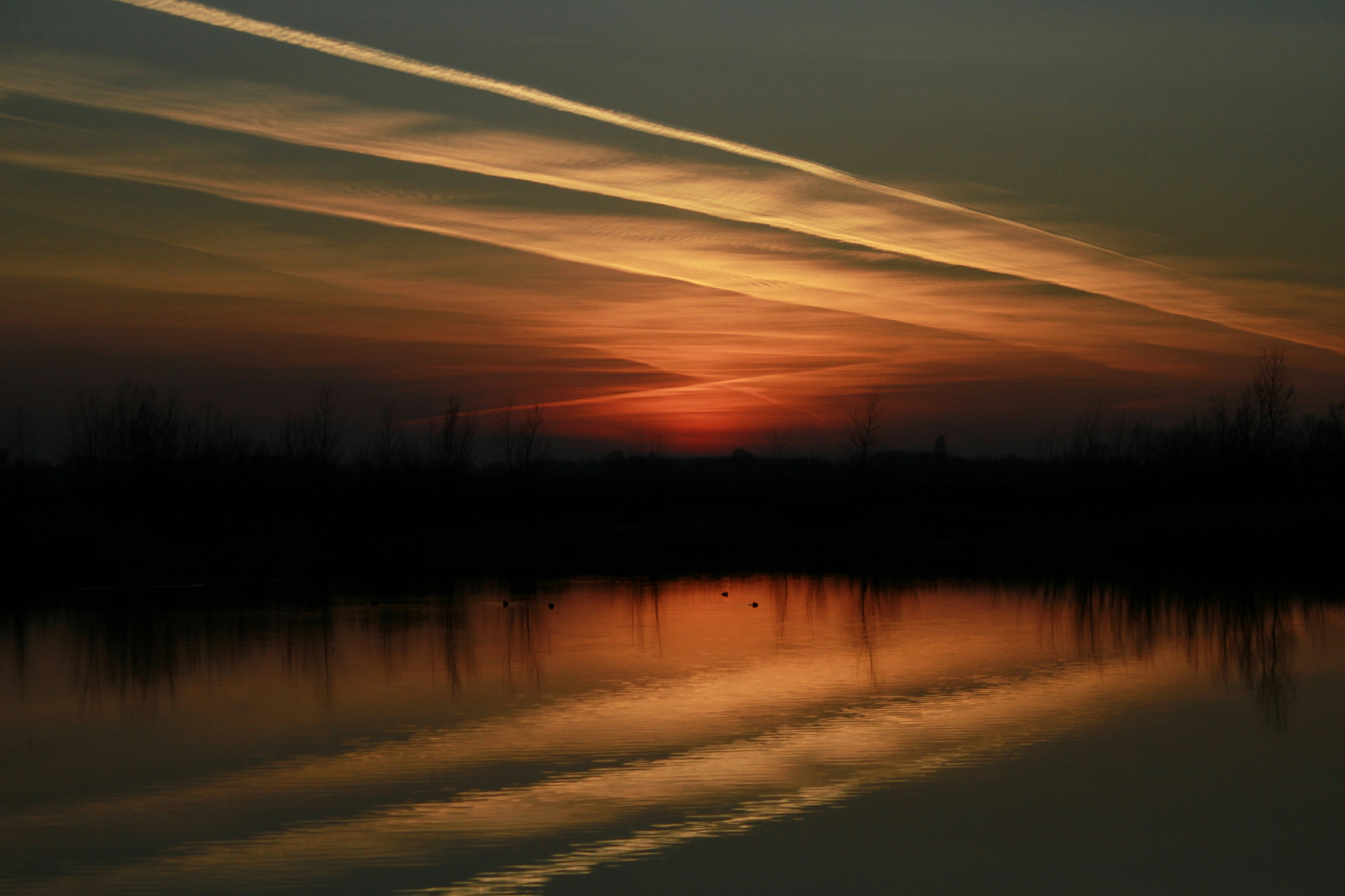 Sunset Contrails Over Lake