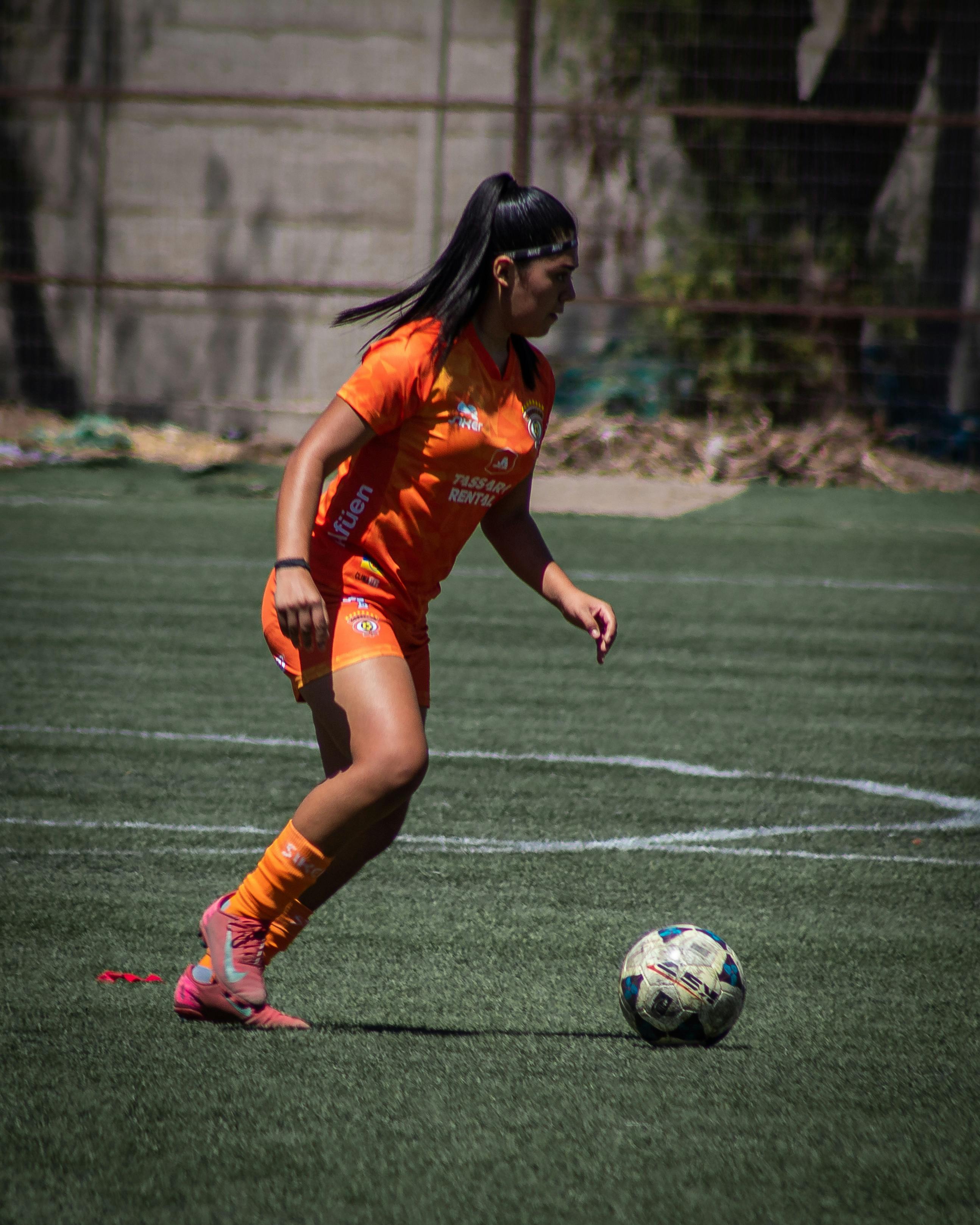 Female Soccer Player Dribbling on Field