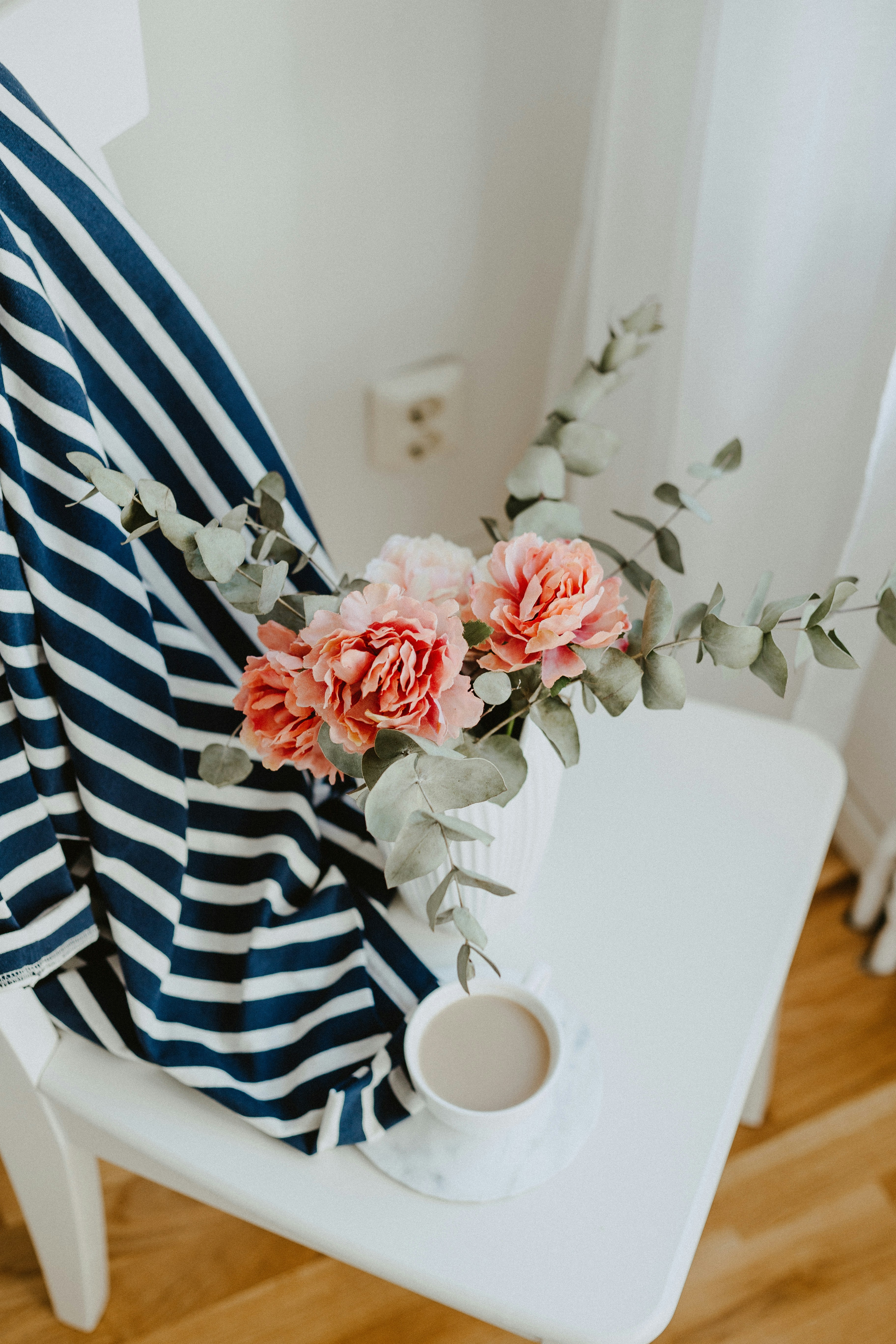 Flowers and coffee on white chair