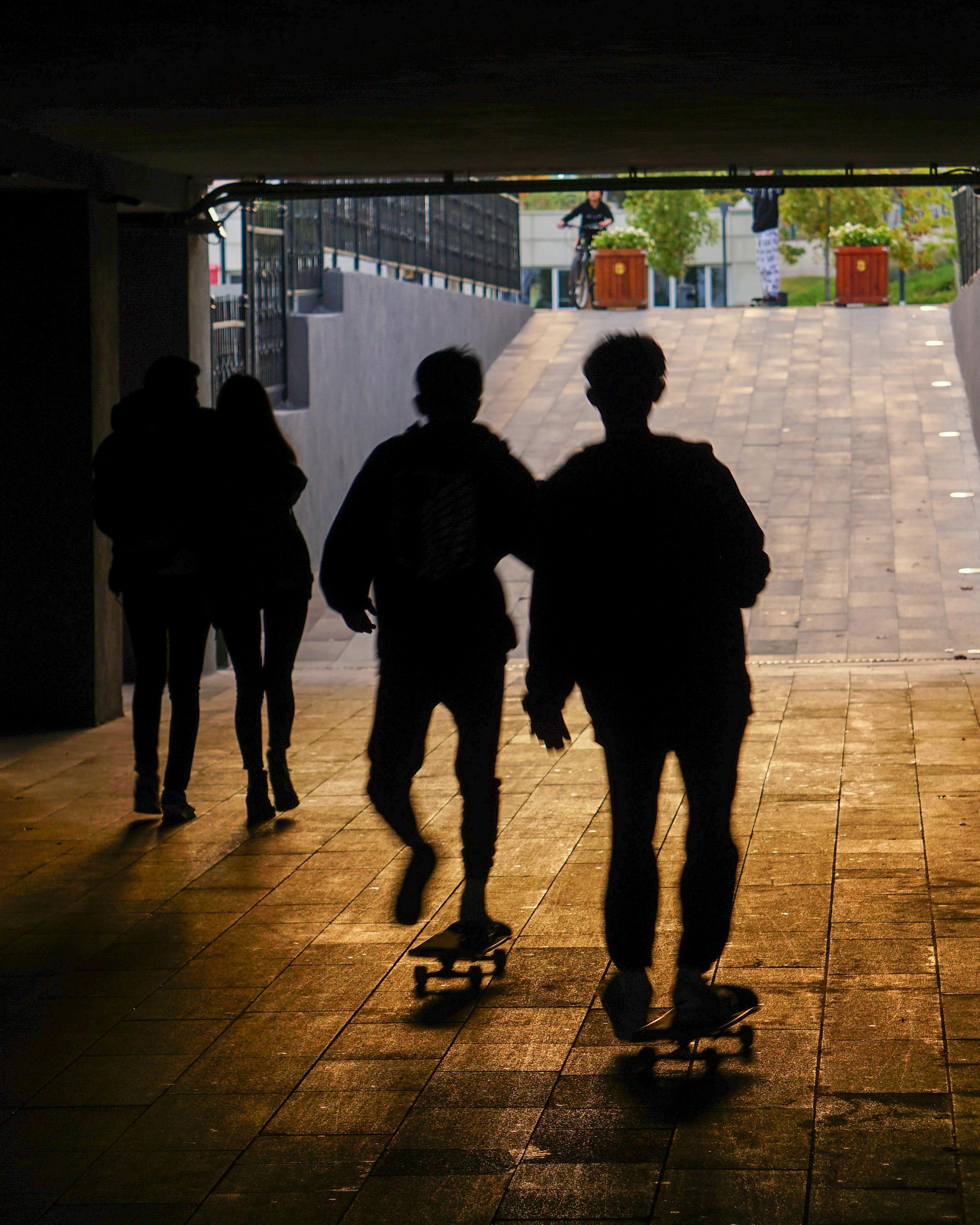 Skateboarders Riding Through Underpass