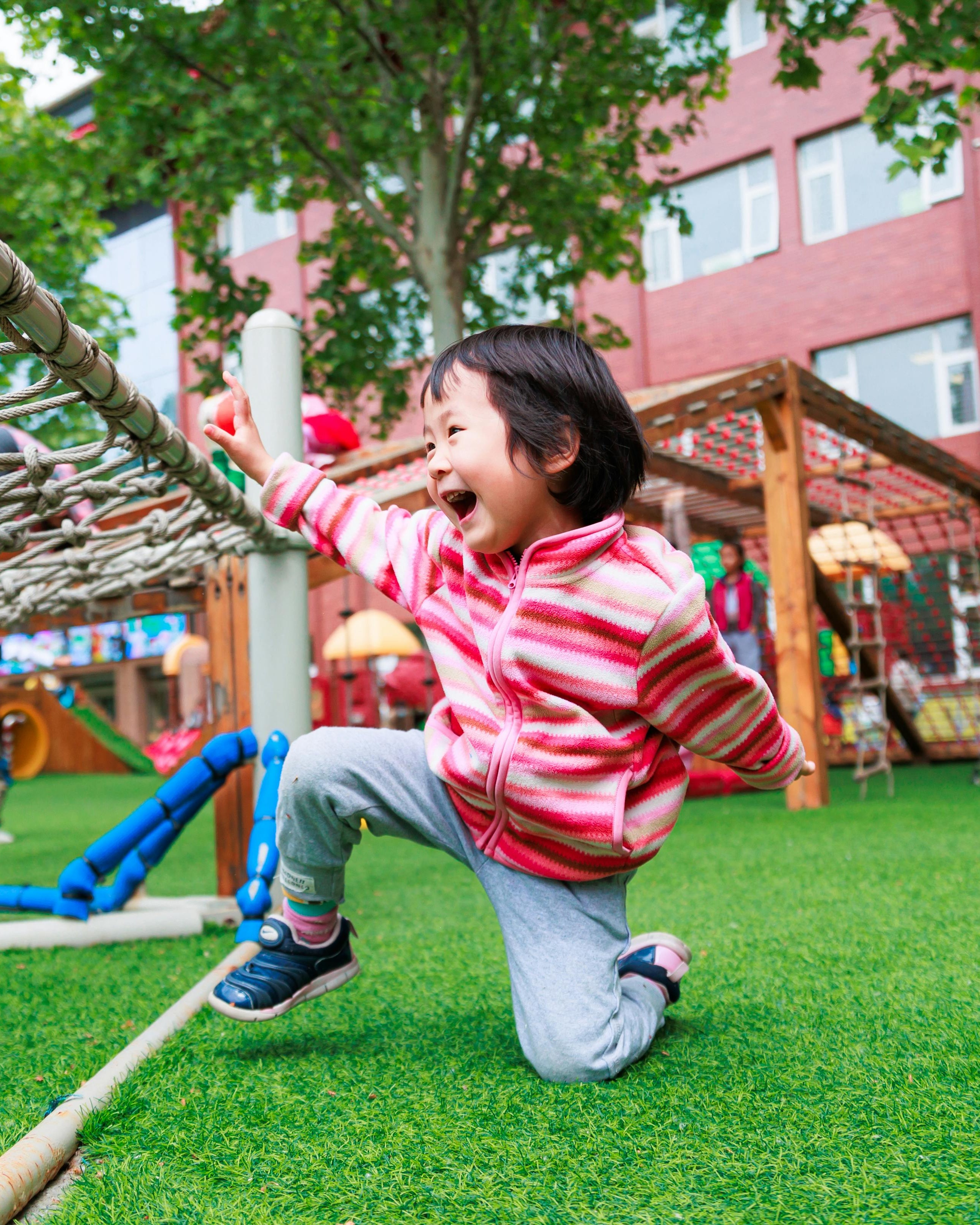 Happy Little Girl Playing at Playground