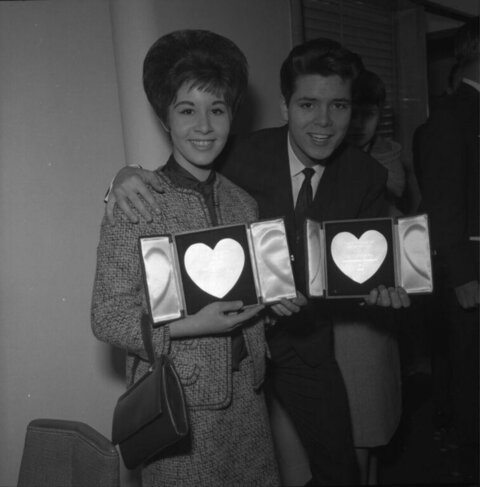 Two People Holding Heart-shaped Awards