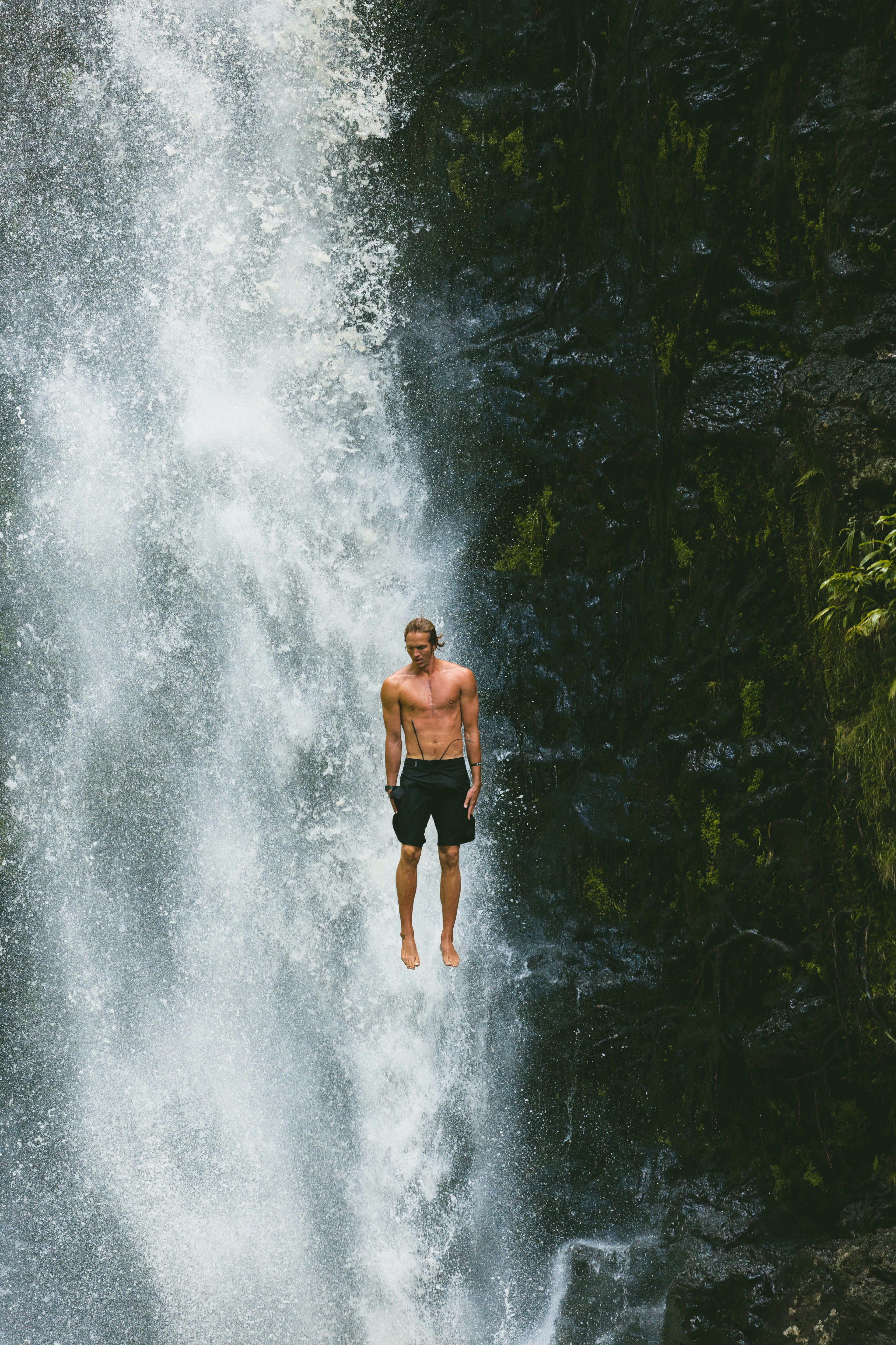 Man jumping into waterfall