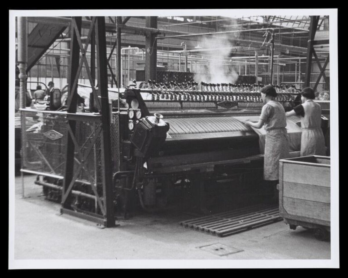 Two Workers Operating Textile Mill Machine