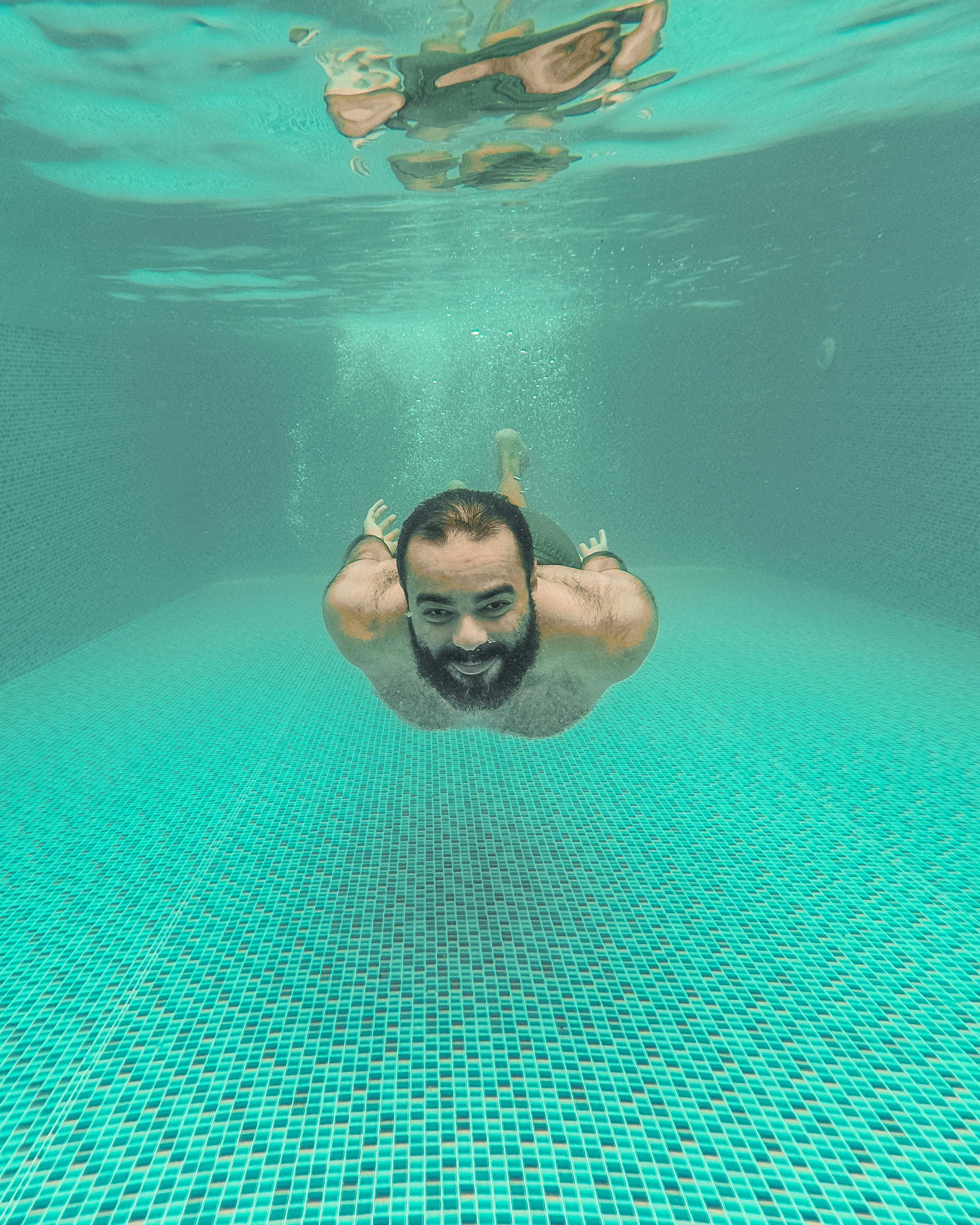 Man Swimming Underwater In Pool