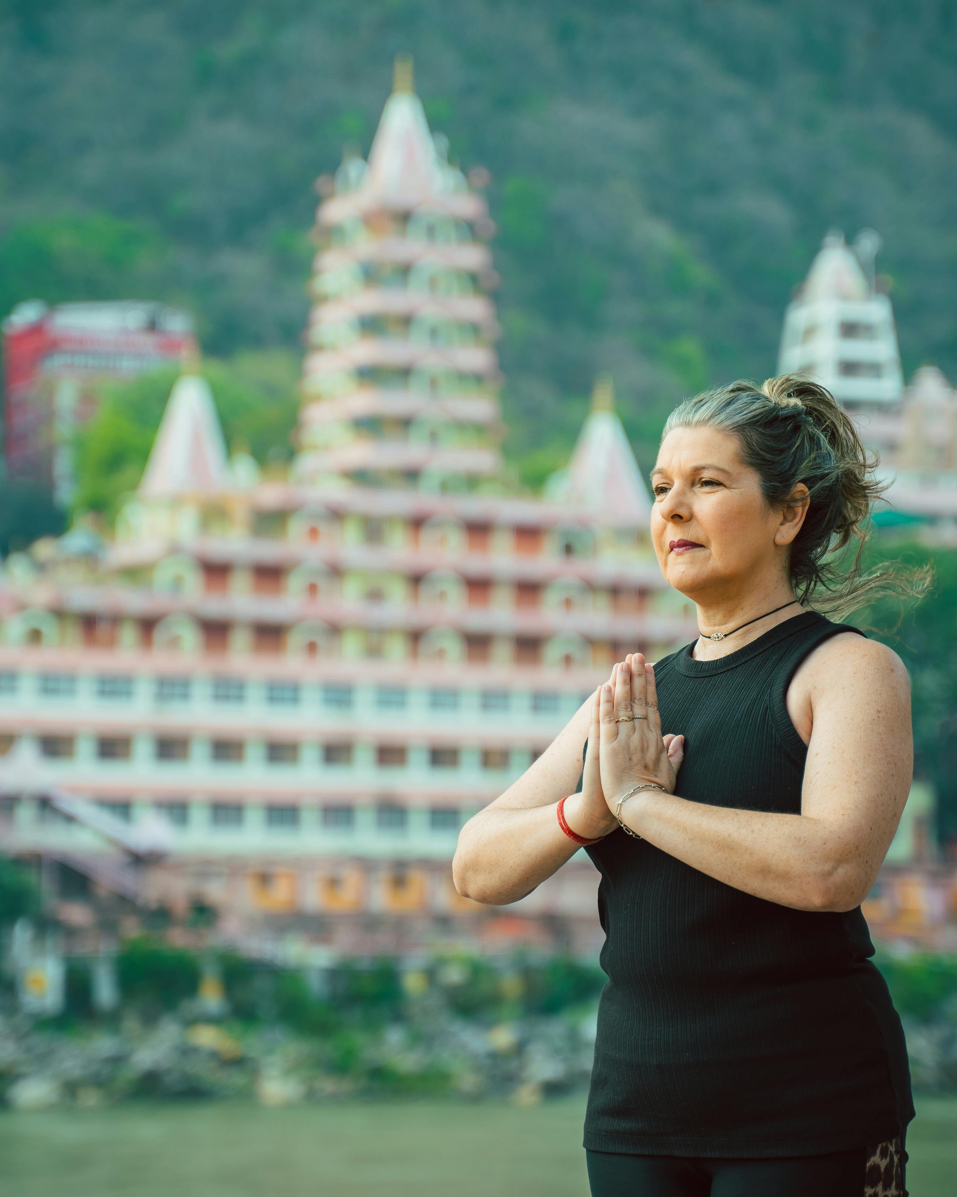 Woman Meditating Near Hindu Temple