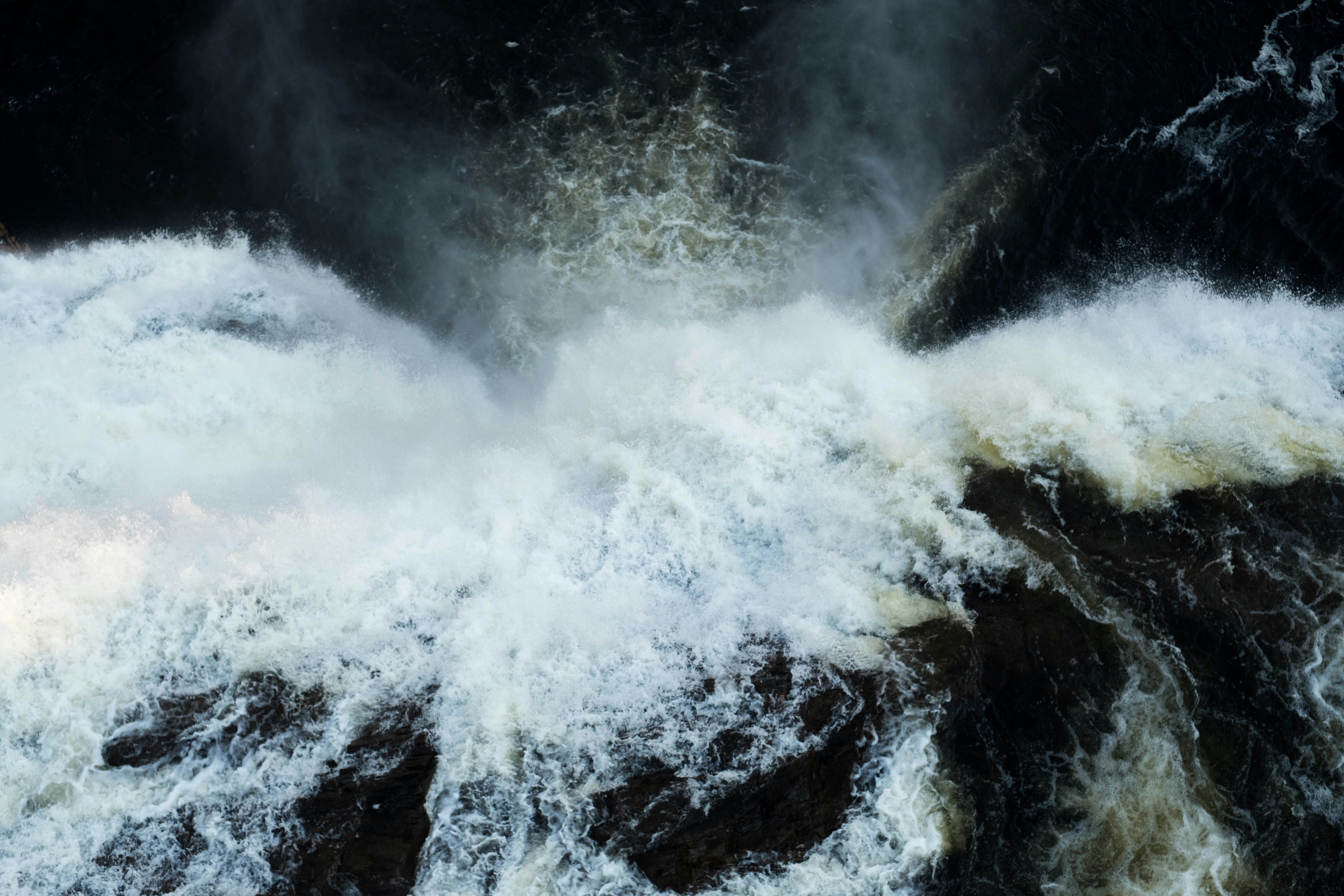 Turbulent Rushing Water Over Dark Rocks