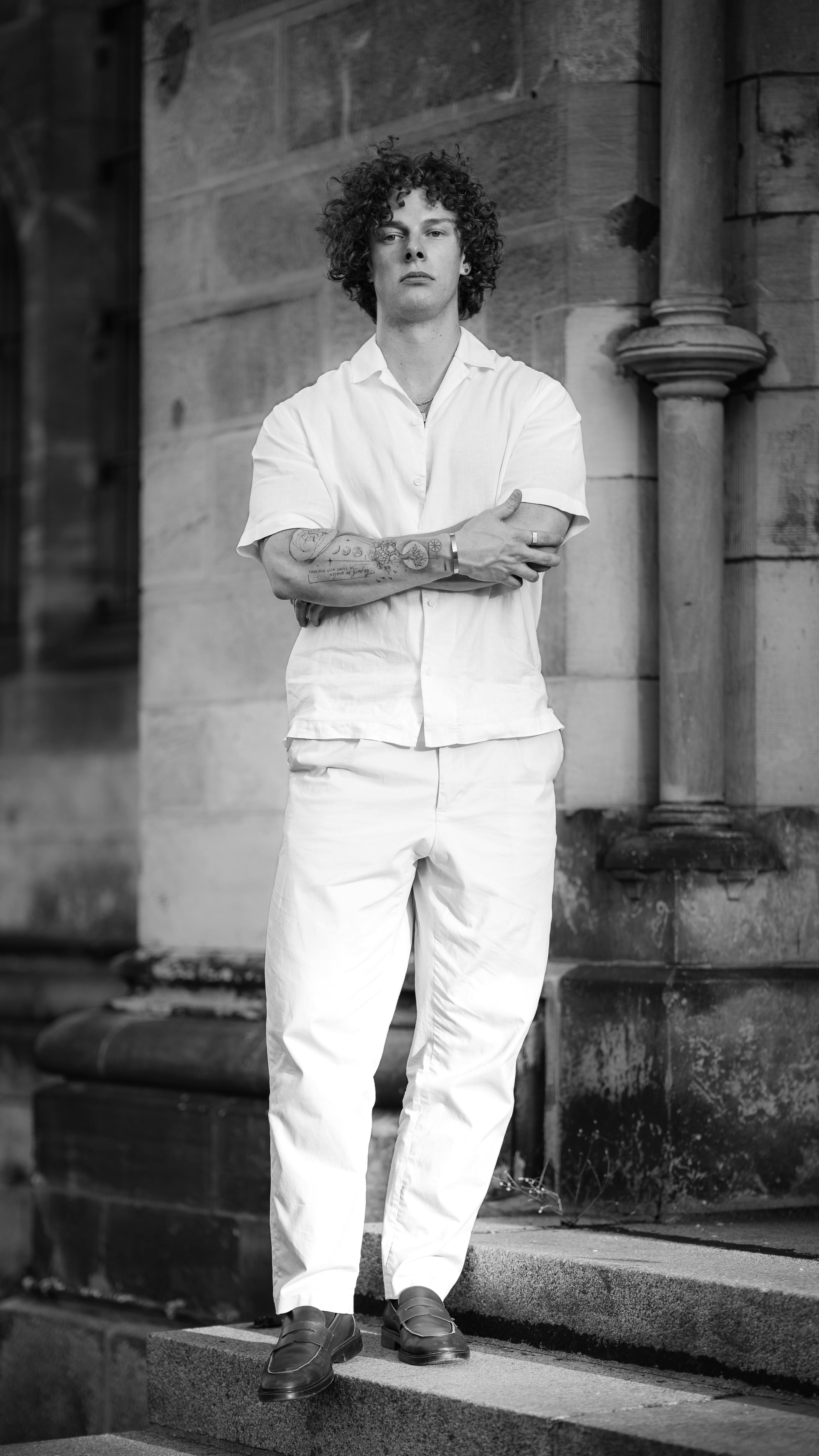 Curly Haired Man in White Outfit Portrait
