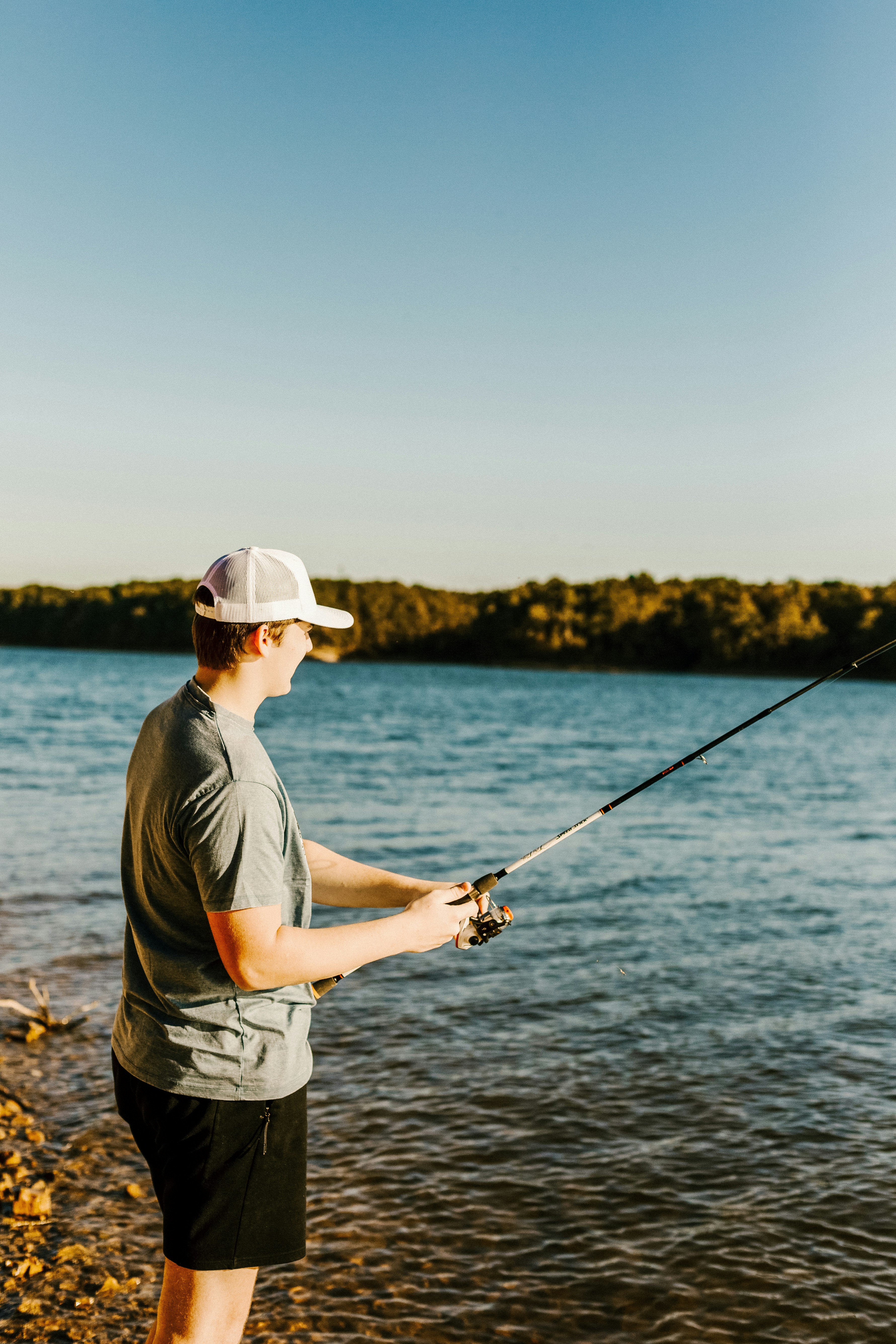 Young Man Fishing by the Lake