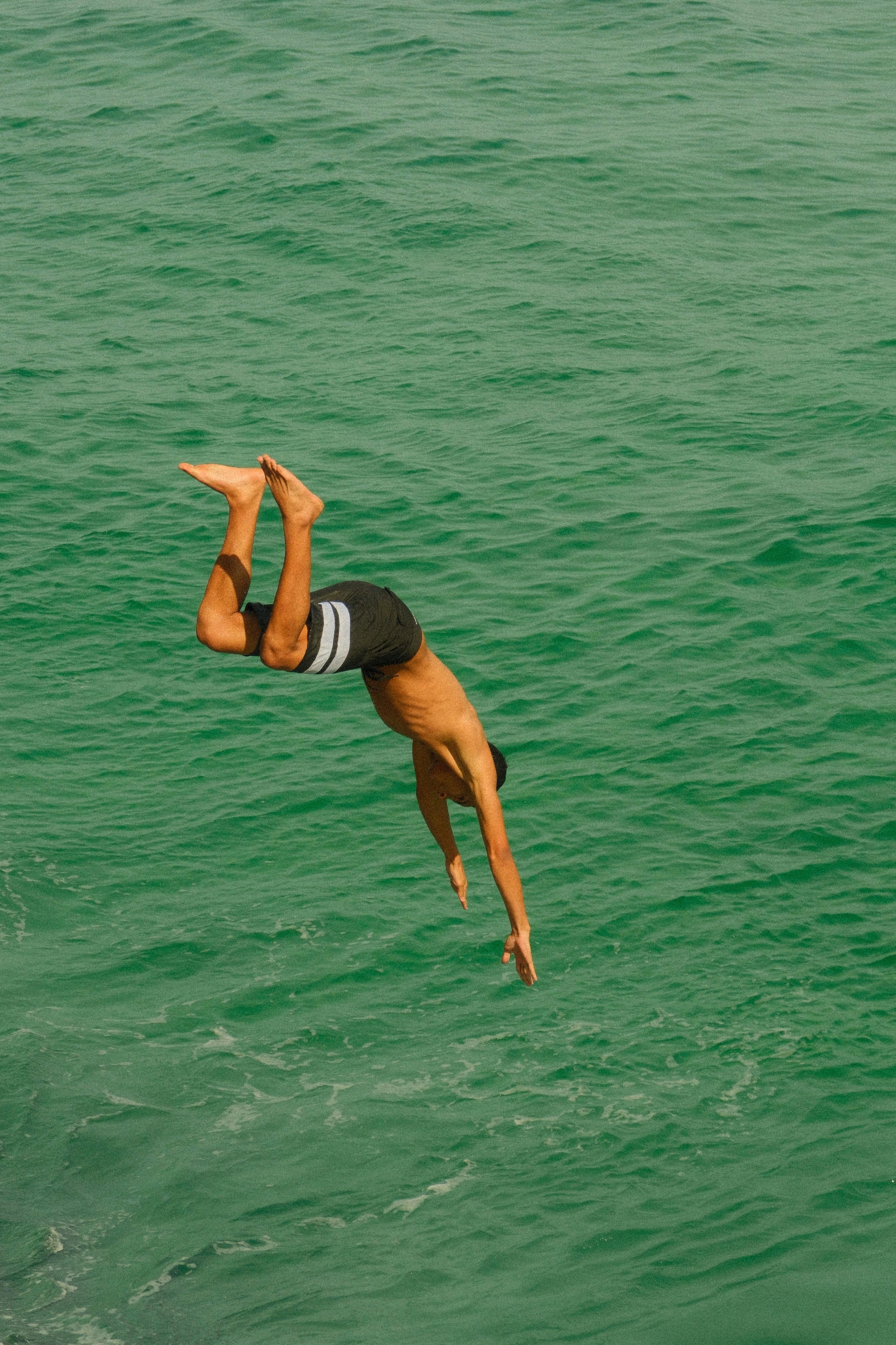 Man Diving into Green Sea