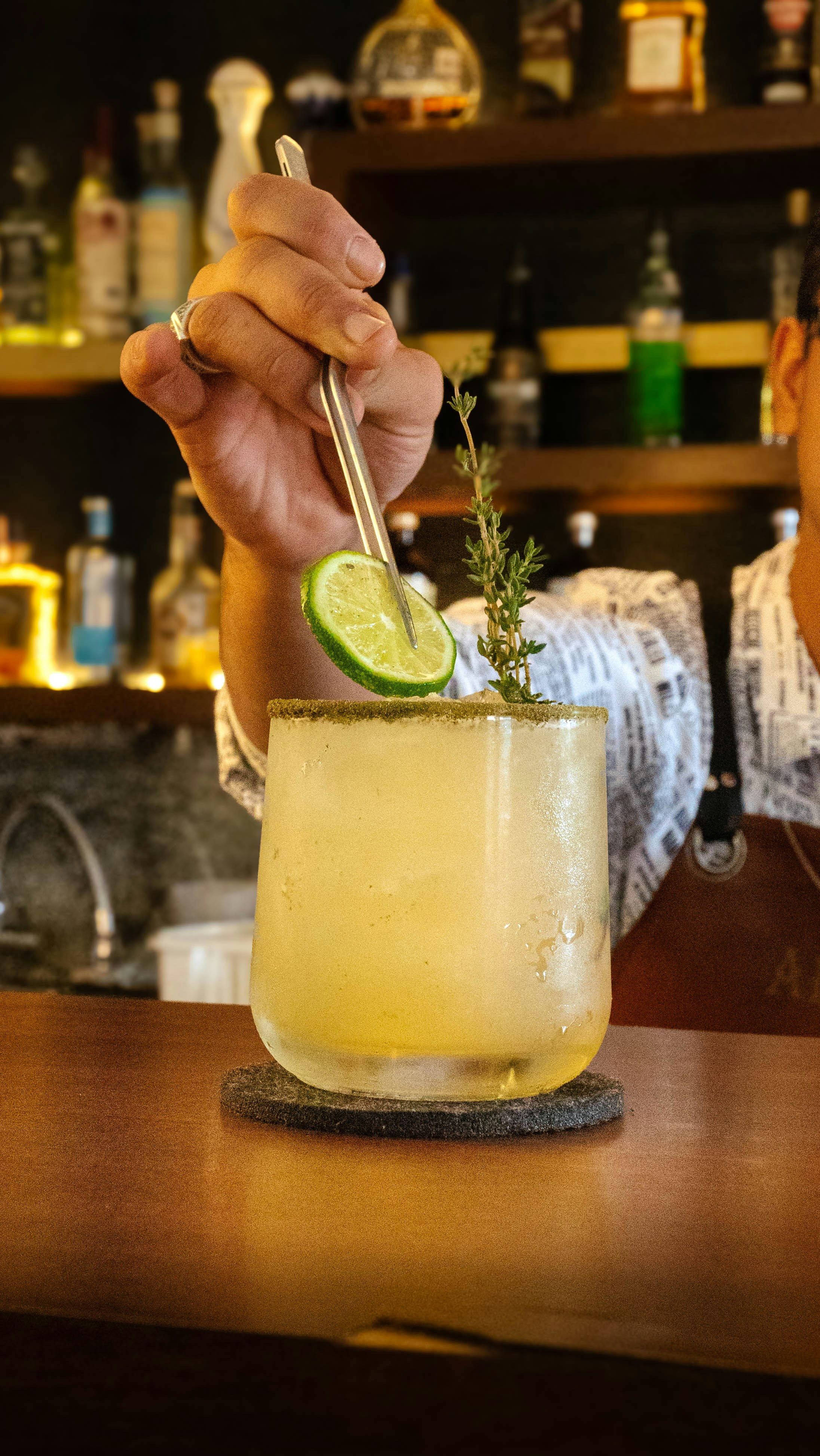 Bartender Garnishing Cocktail at Bar