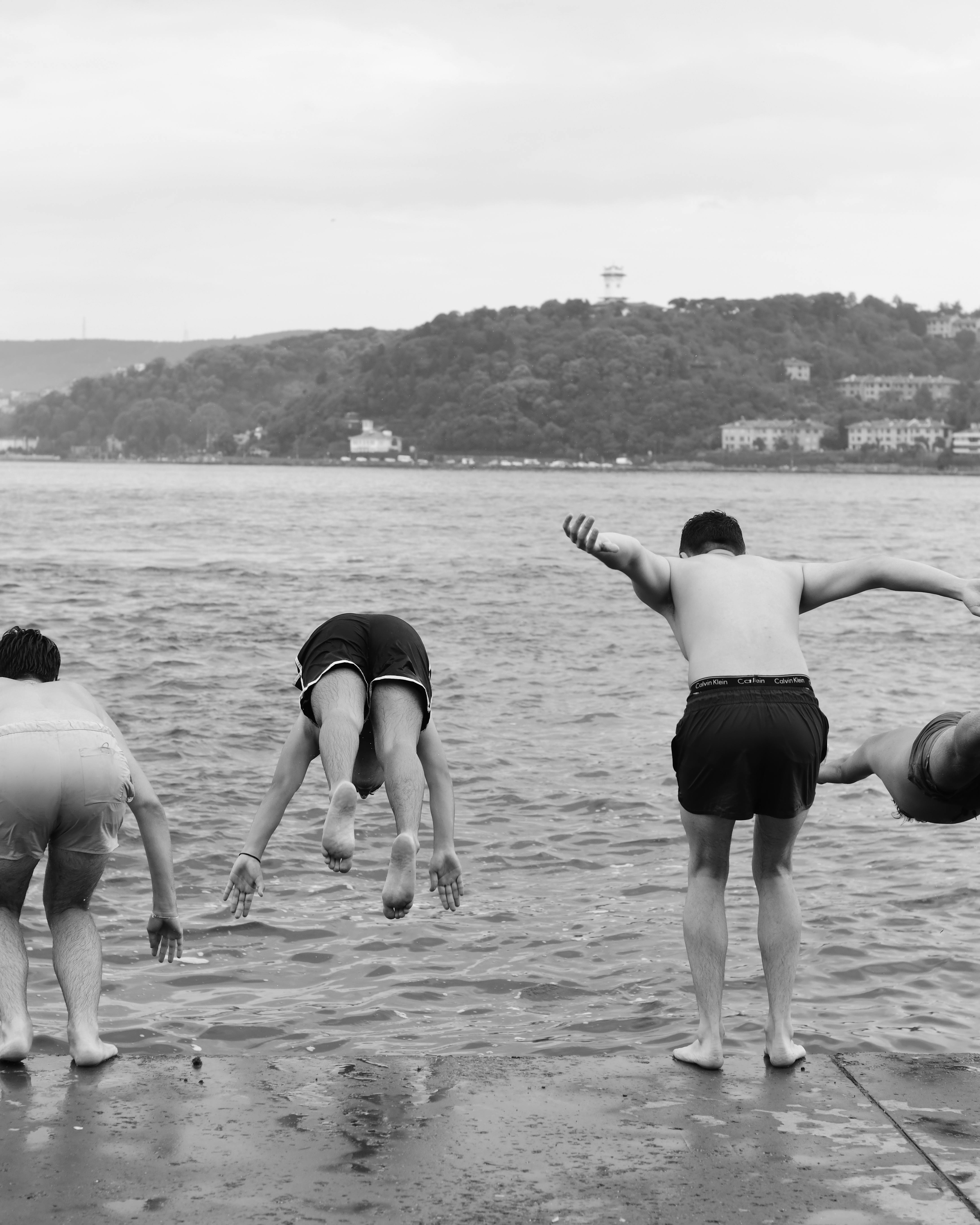 Four Men Diving Into Water