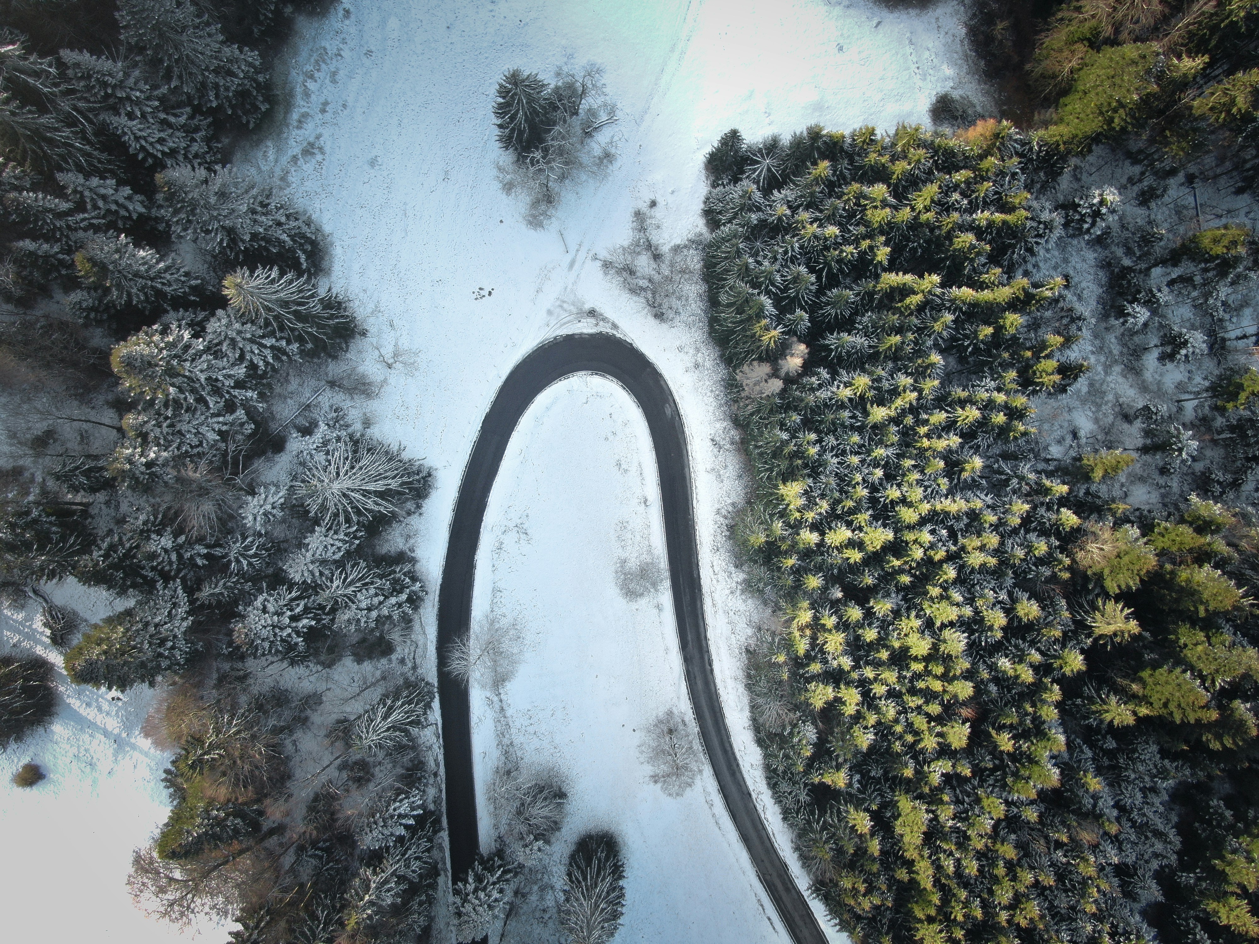 Aerial View of Snowy Forest Winding Road