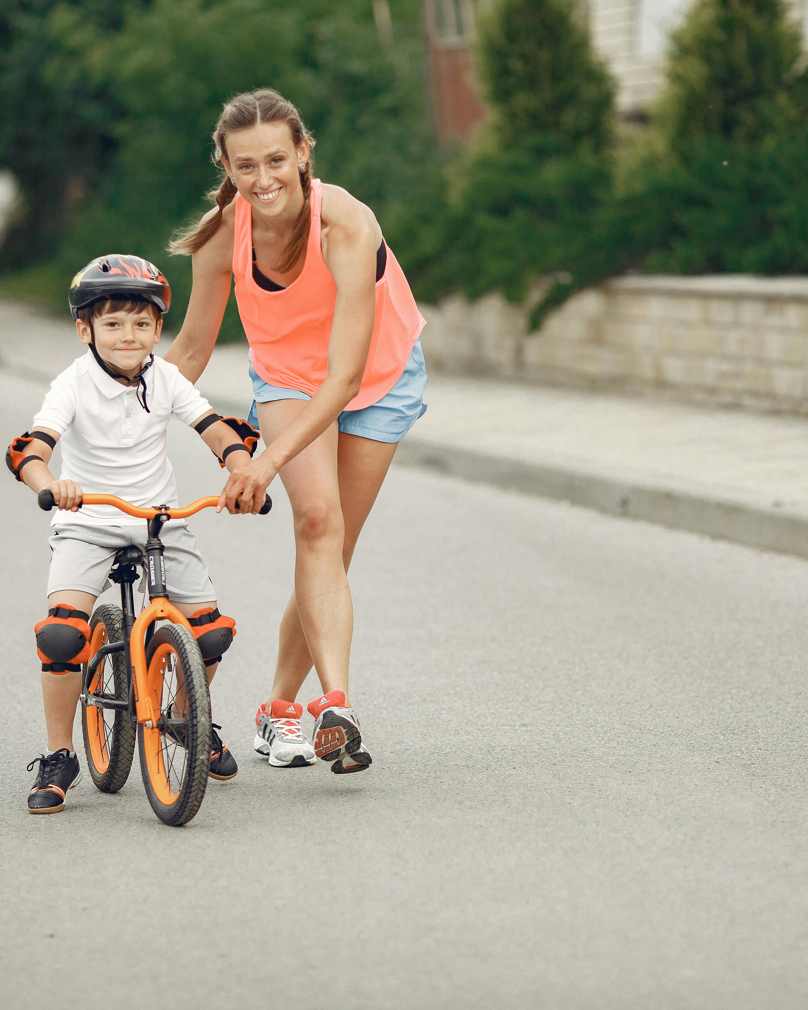 Woman Teaching Boy To Ride Bicycle