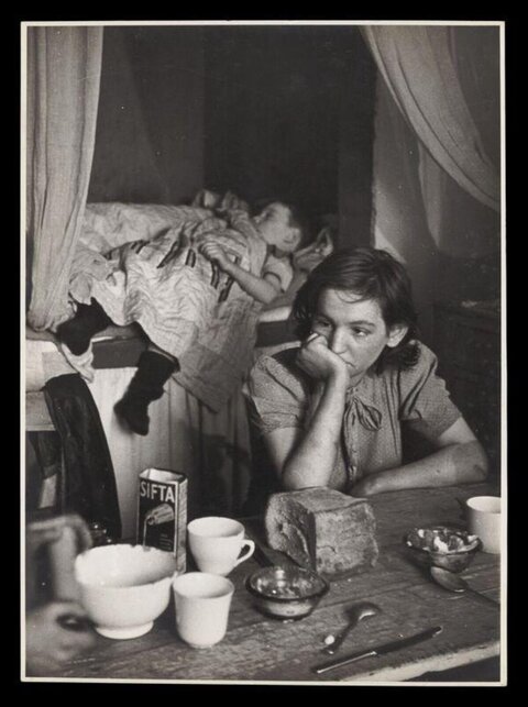Worried Mother At Table With Sleeping Child
