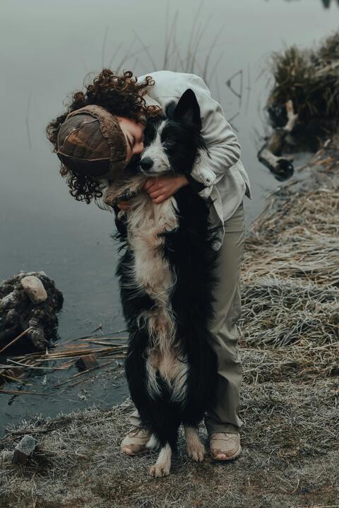 Woman Hugging Dog by Frosty Water's Edge