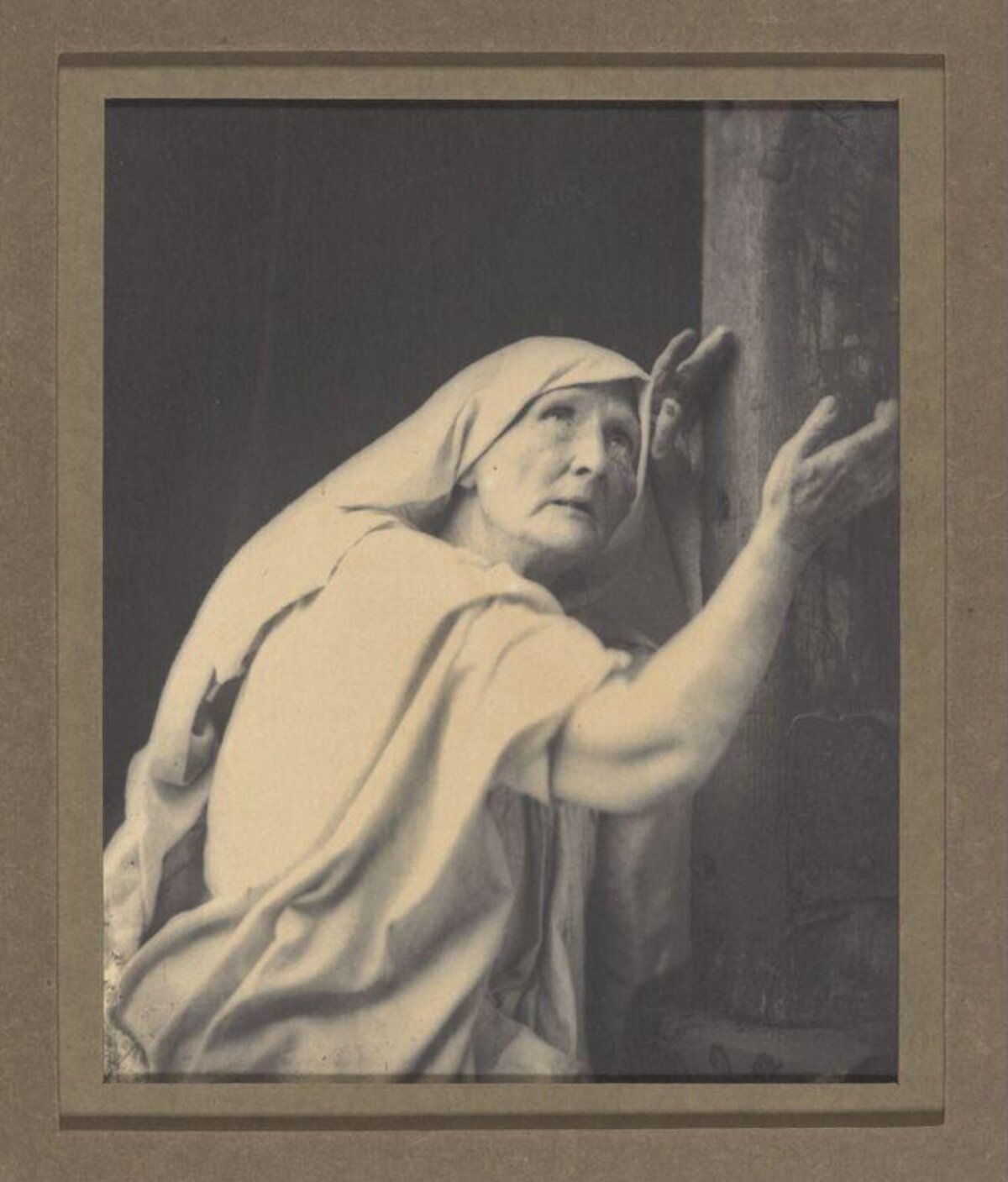 Elderly Woman Listening at Column