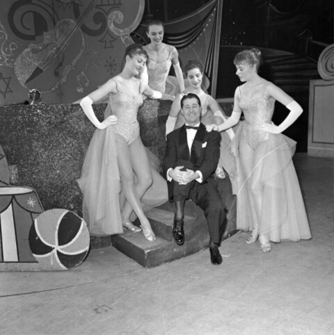 Man Surrounded by Showgirls on Stage