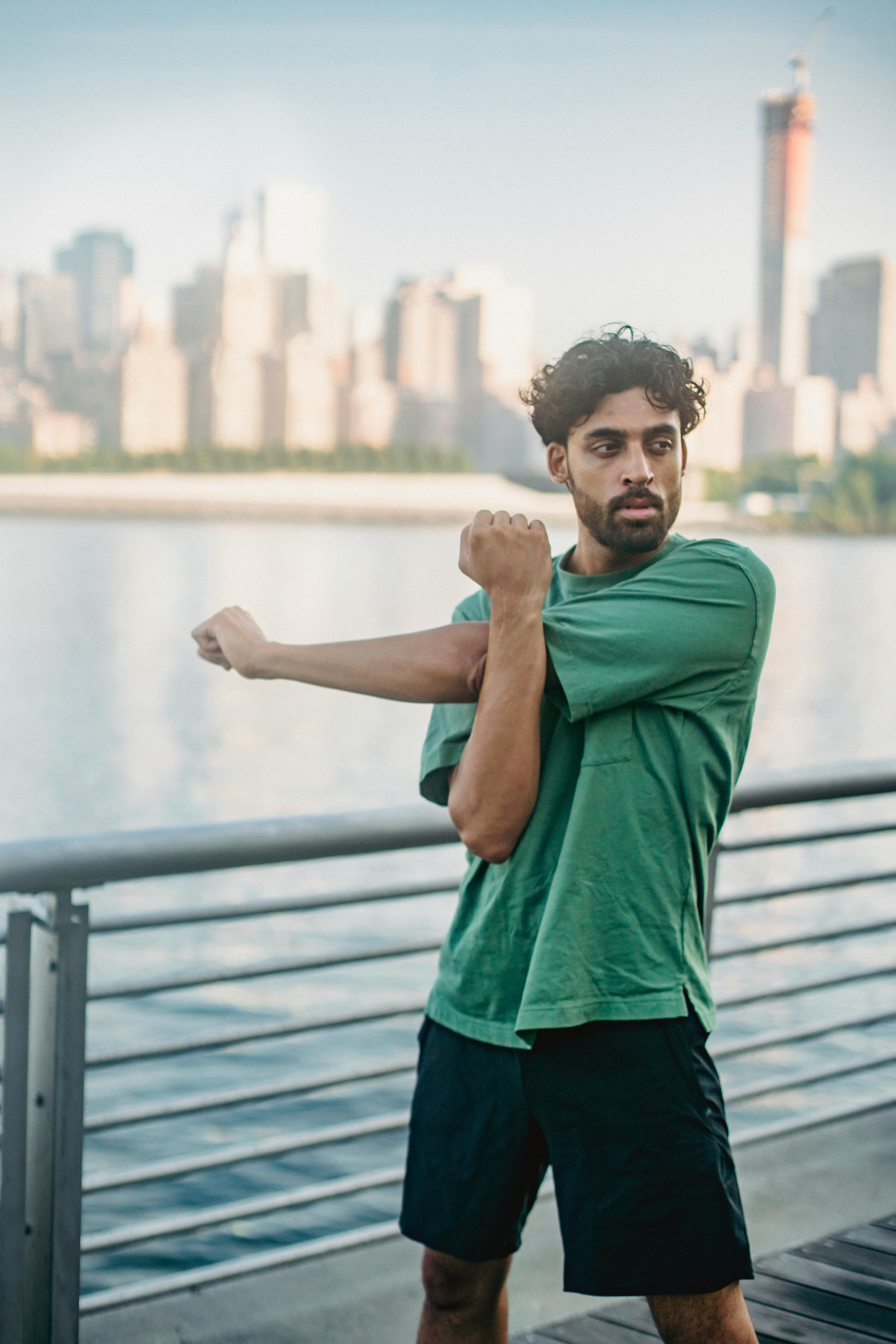 Man Stretching By City Riverfront