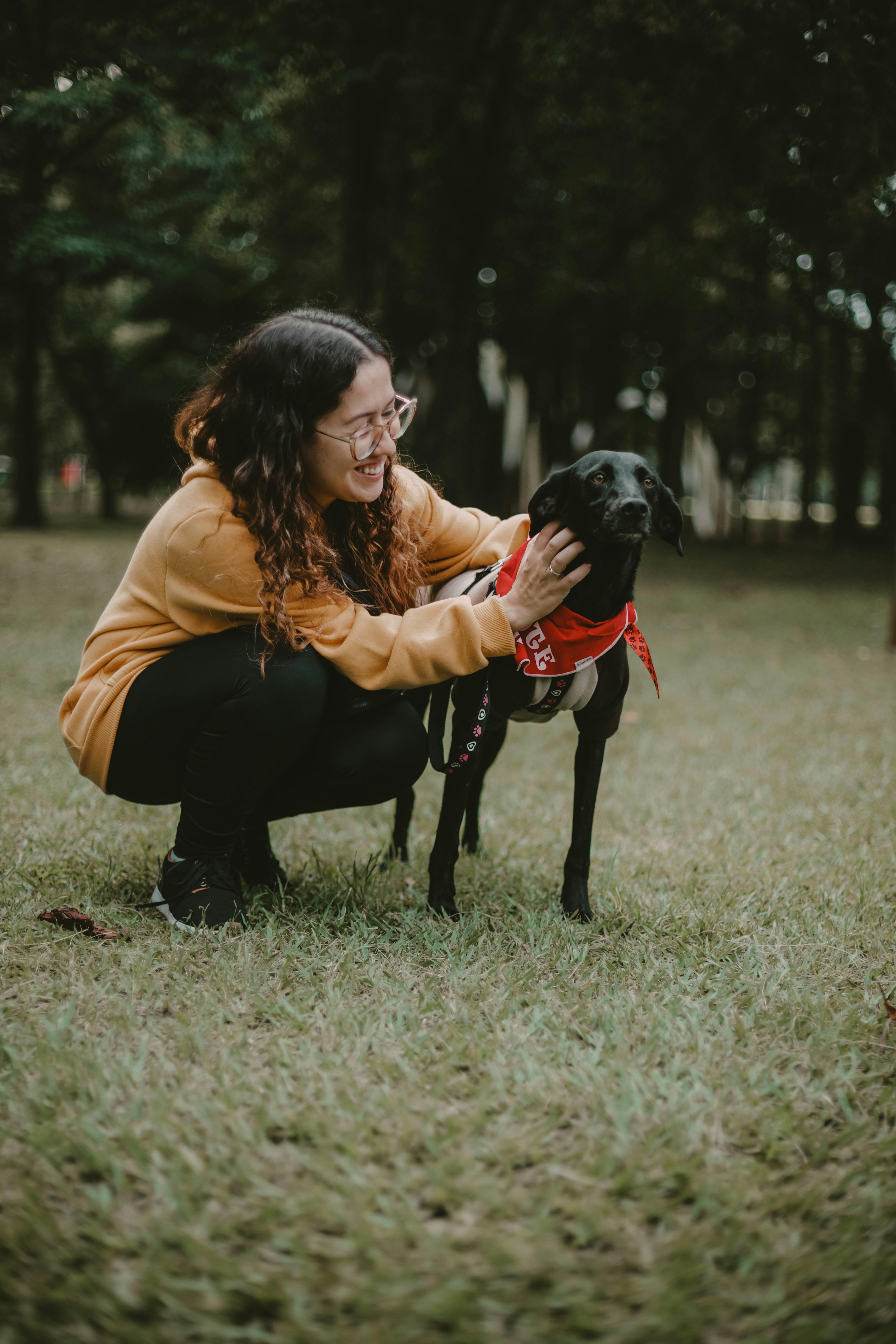 Woman Crouching With Dog In Park