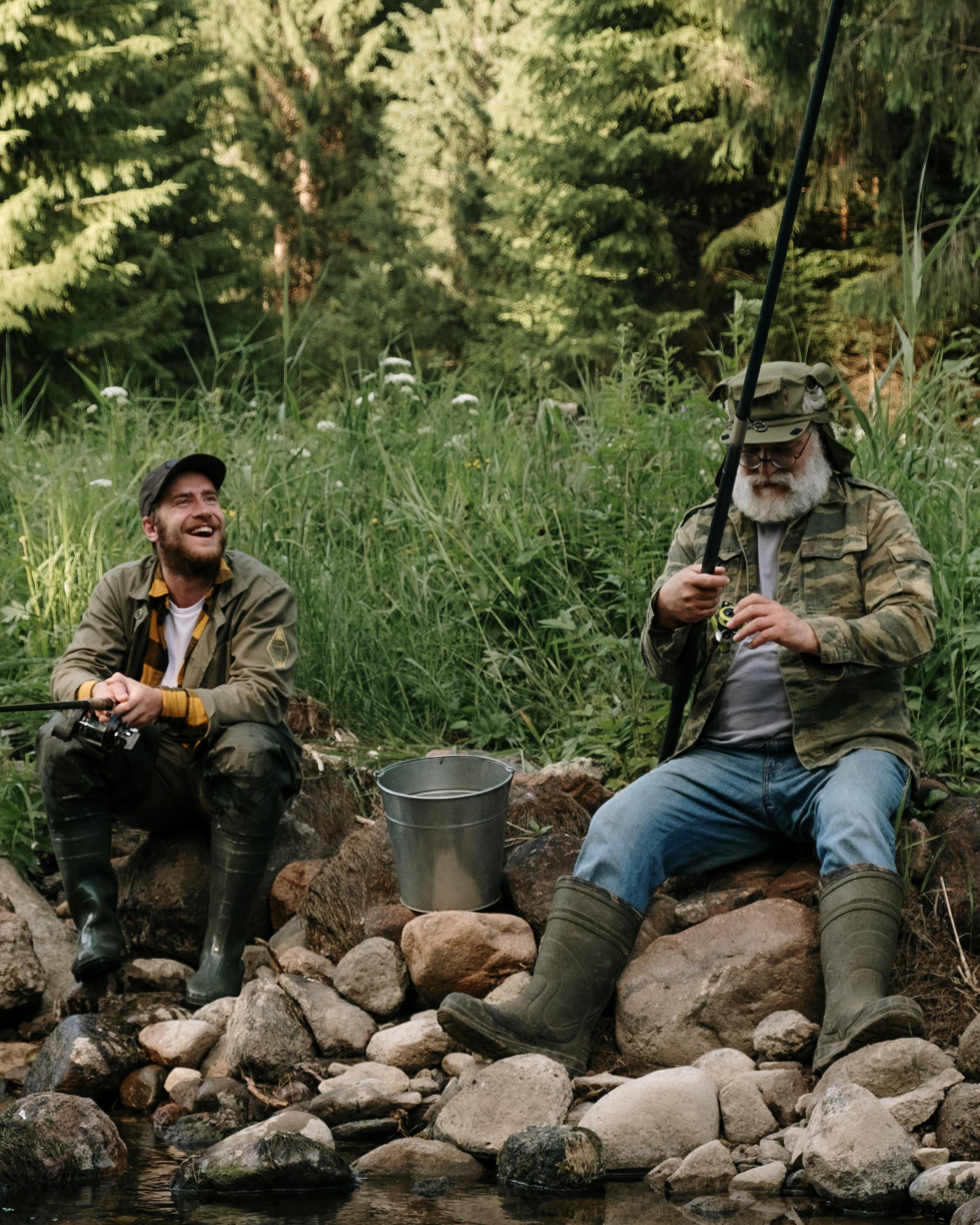 Two Men Fishing on Rocky Riverbank