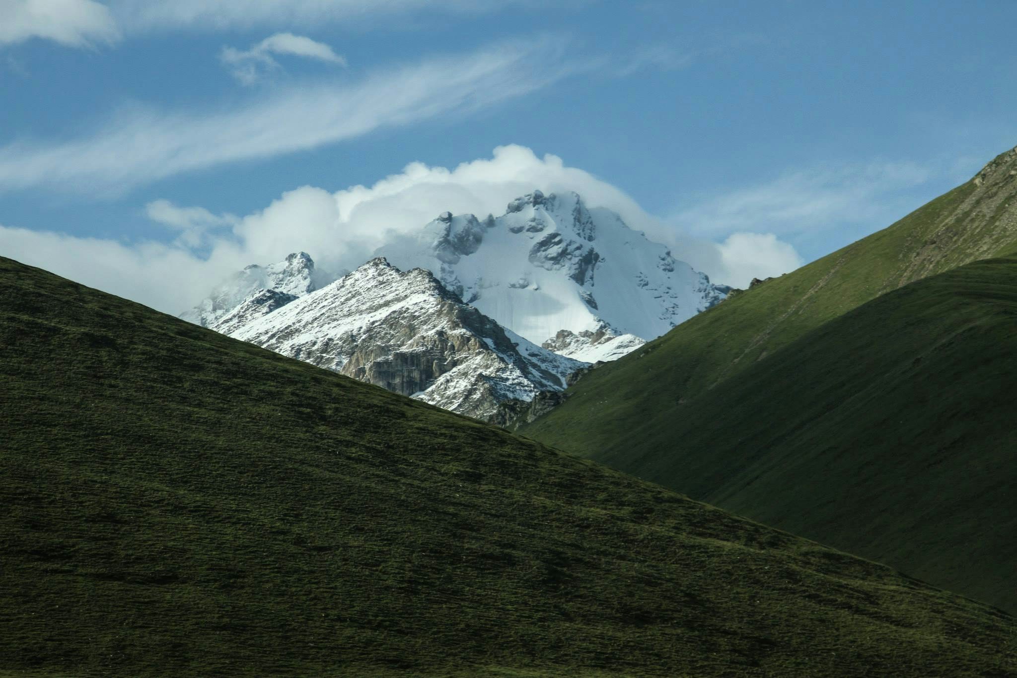 Snow-capped Mountain Between Green Hills