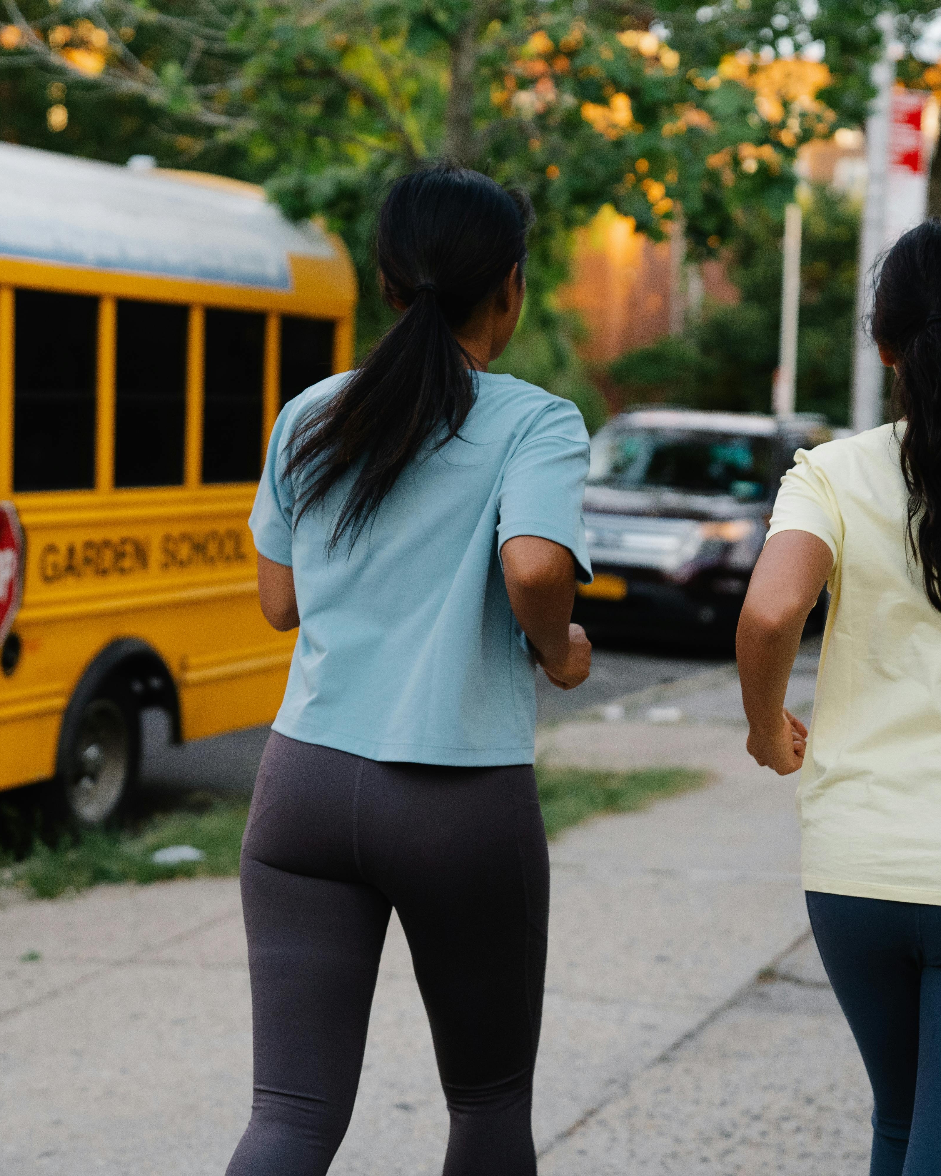 Two Women Jogging on Urban Sidewalk