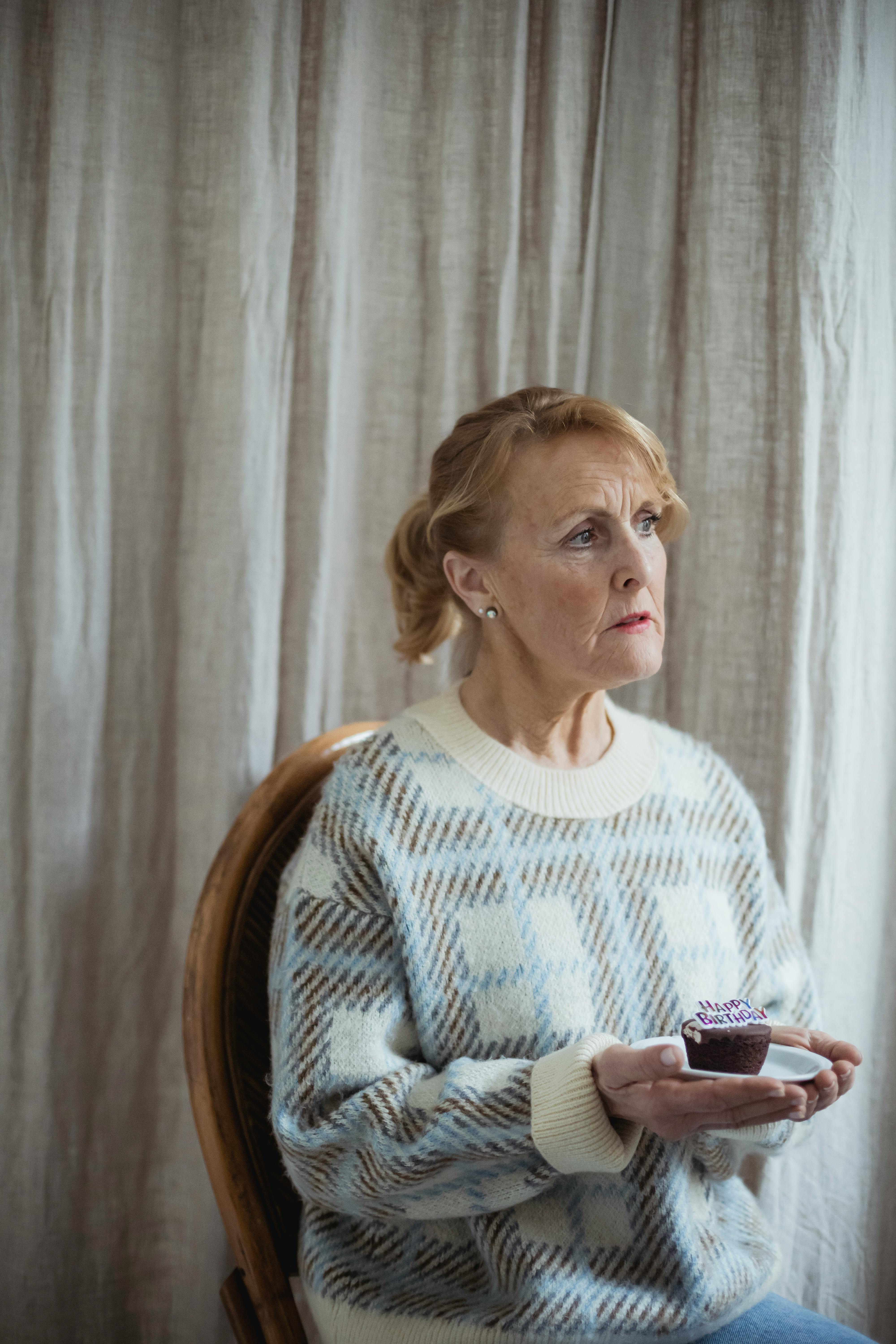Pensive Woman Holding Birthday Cupcake