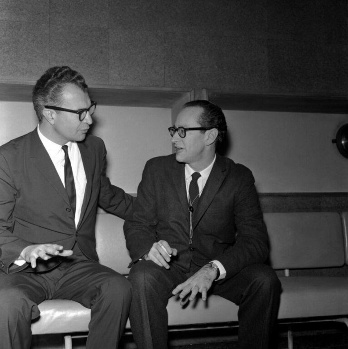 Two Men In Suits Chatting On Bench