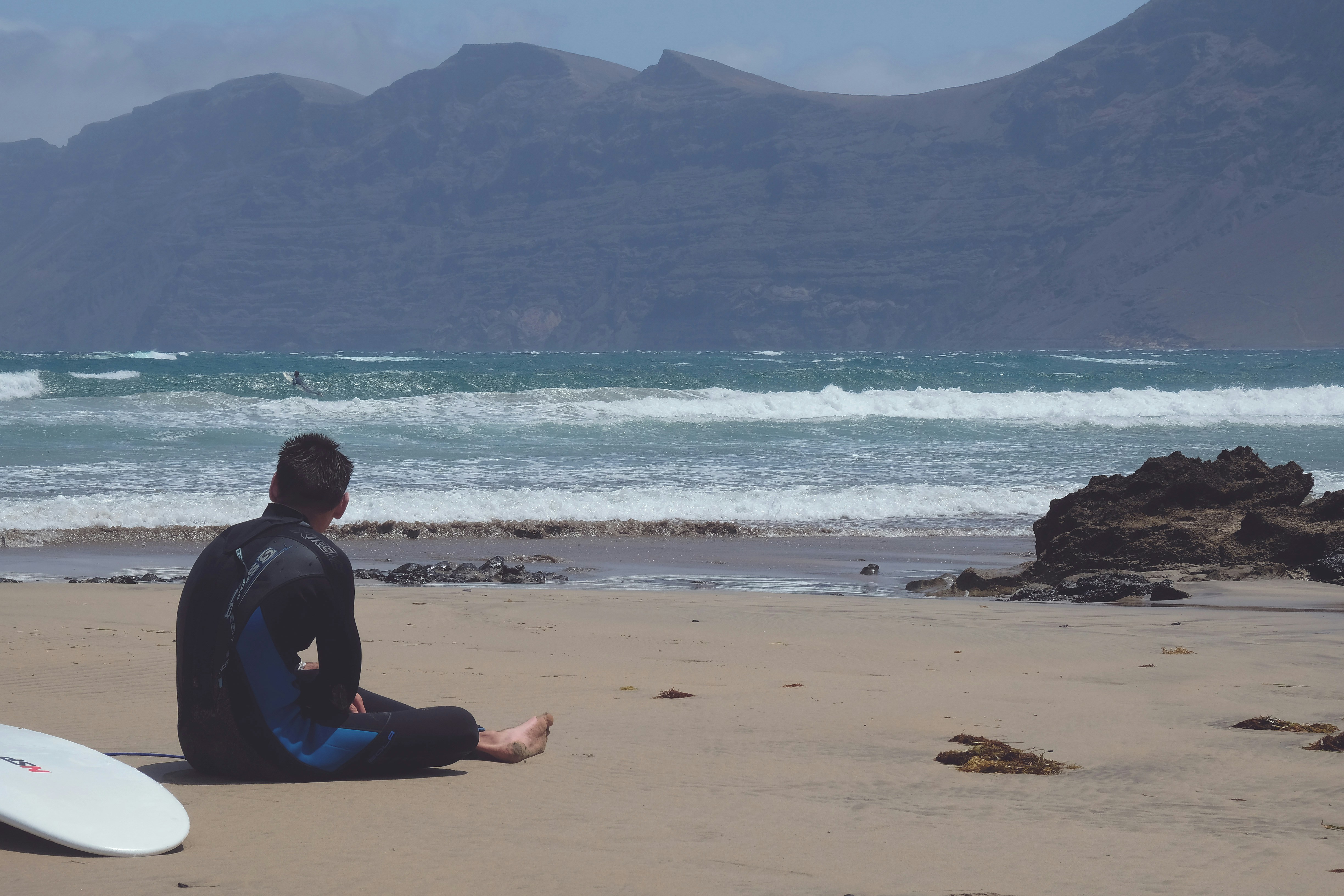 Surfer Resting on Sandy Beach