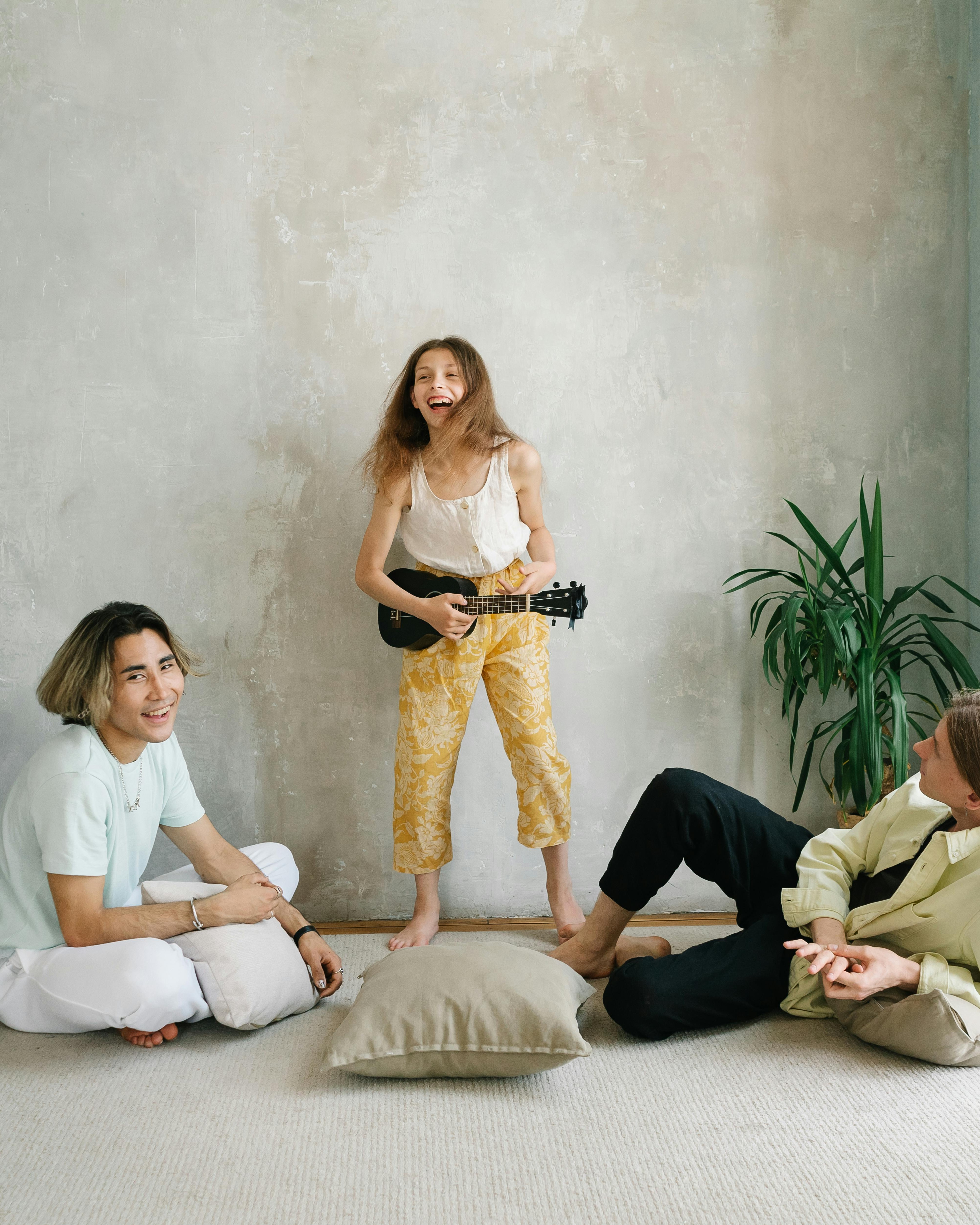 Girl Playing Ukulele With Friends Indoors
