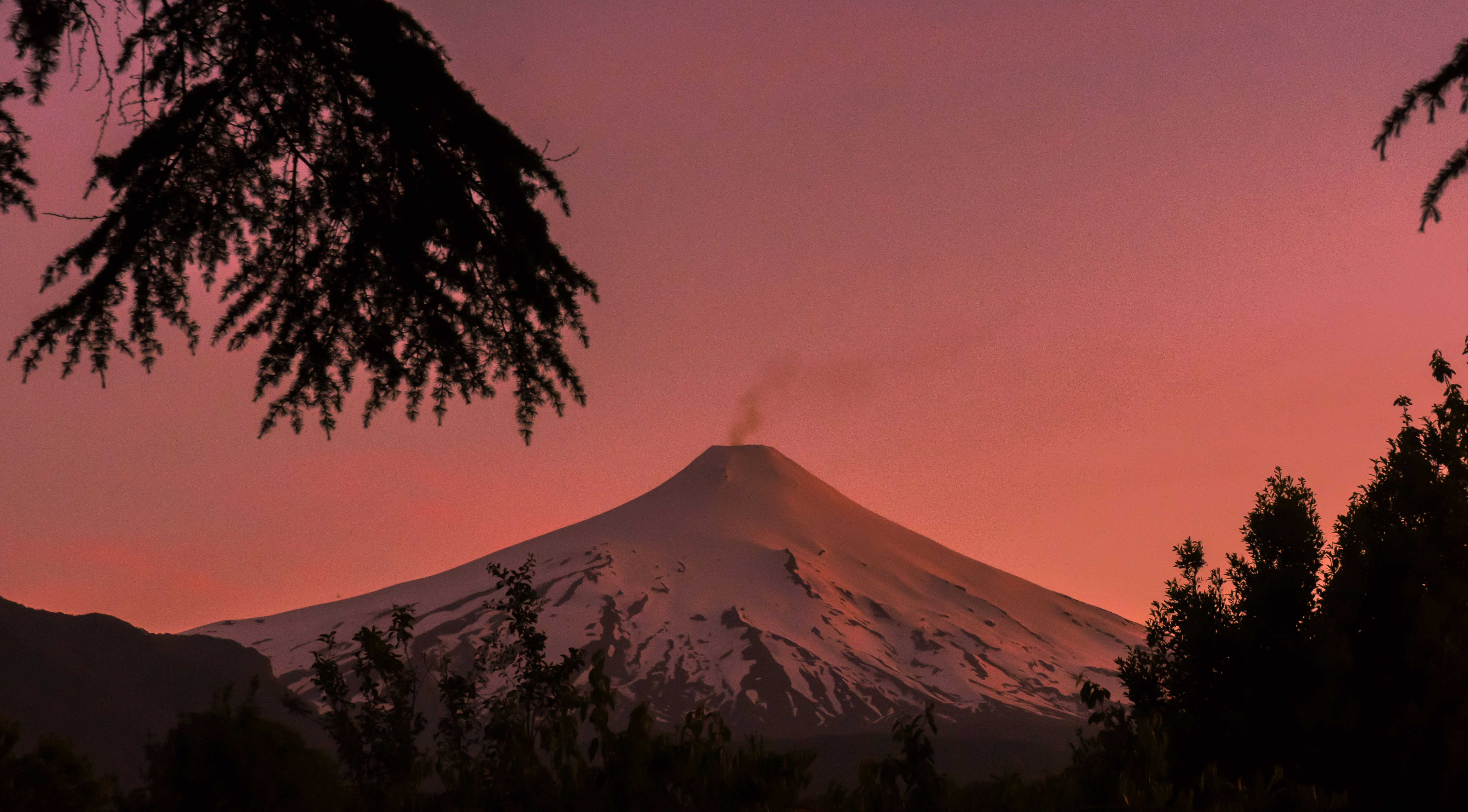 Smoking Snow-capped Volcano at Dusk