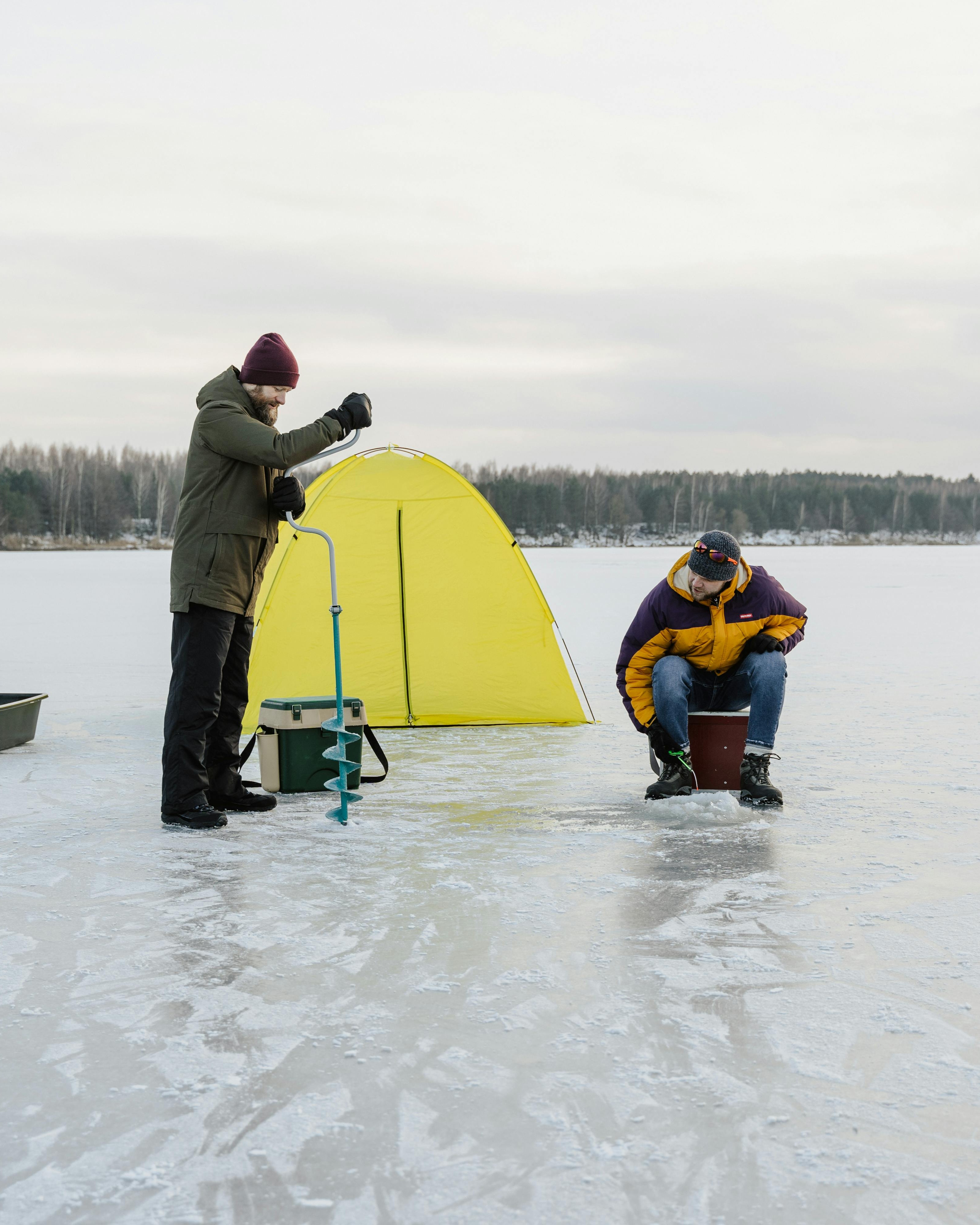Two Men Ice Fishing on Frozen Lake