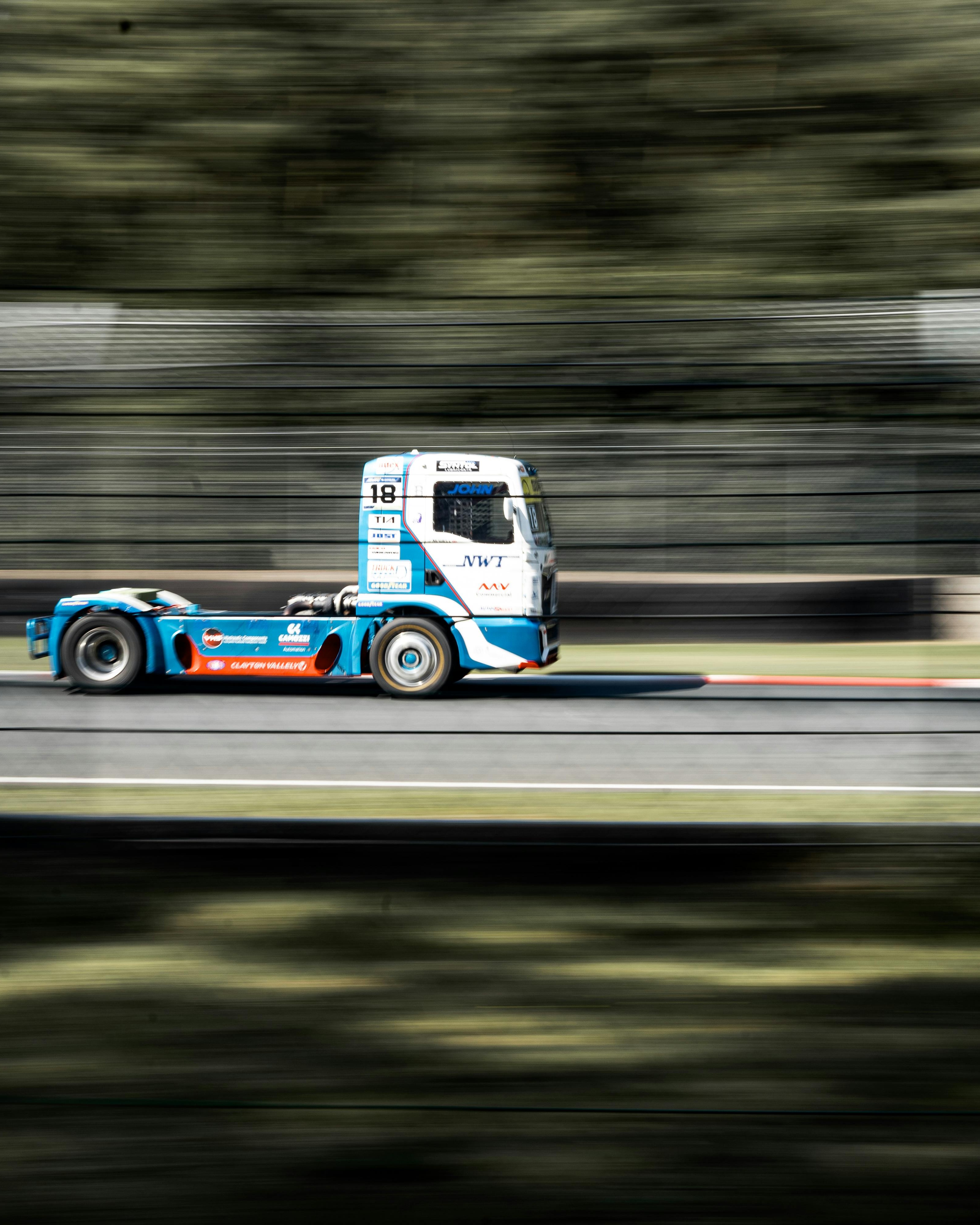 Blue Racing Truck Speeding on Race Track