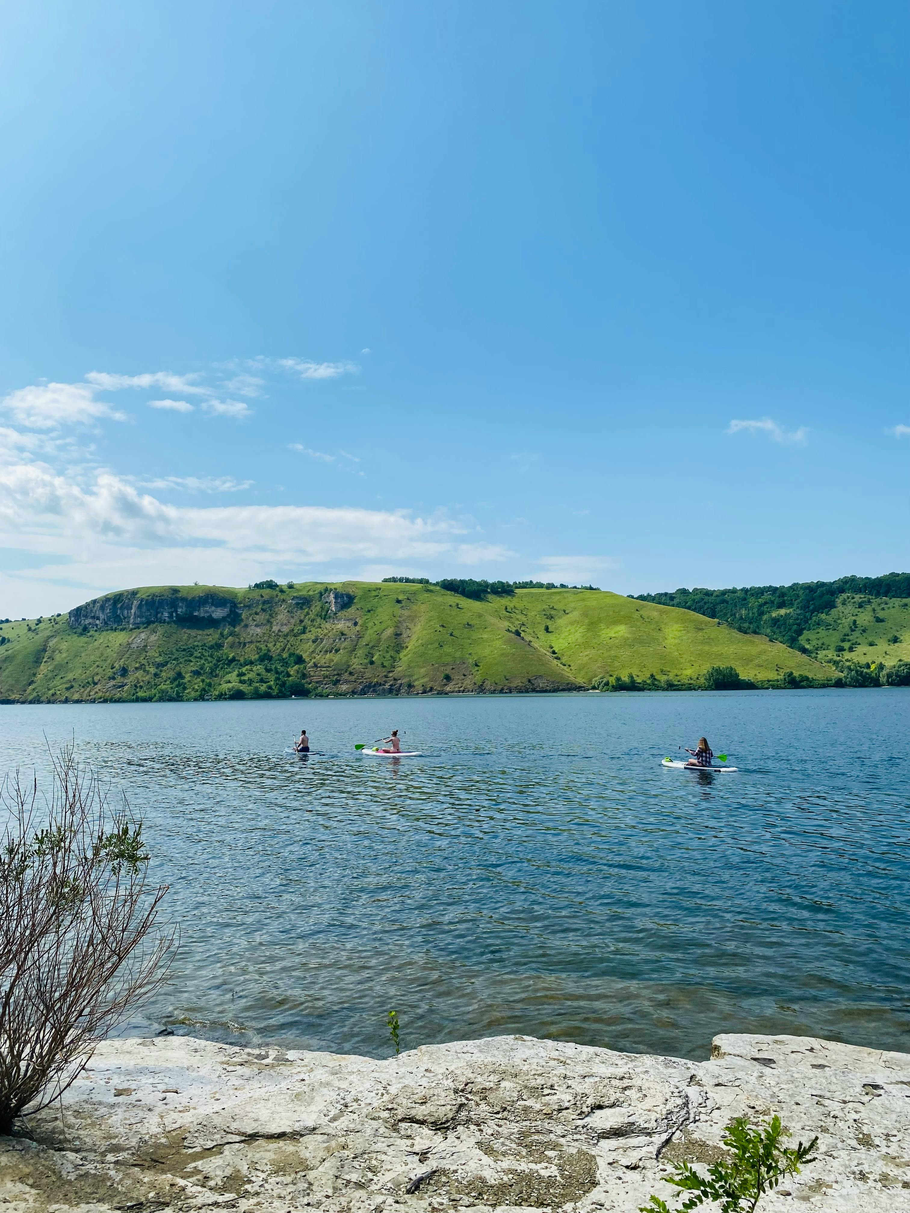 Paddleboarding on Calm Lake with Green Hills
