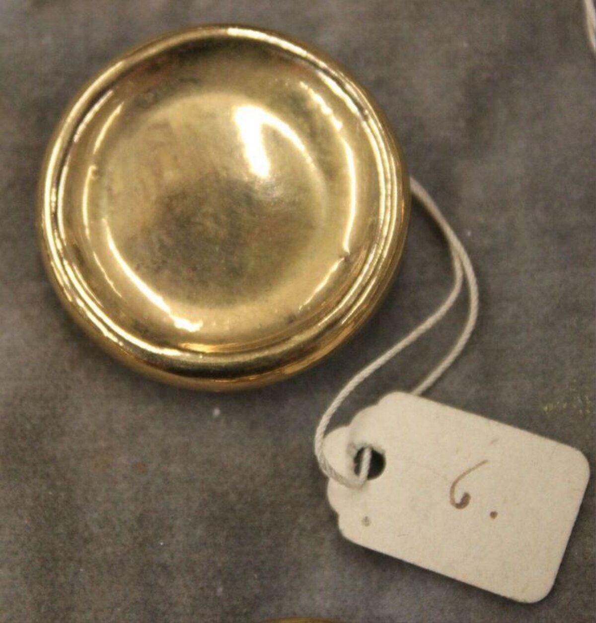 Polished Brass Round Object With Tag