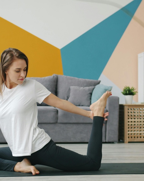 Woman Practicing Yoga At Home
