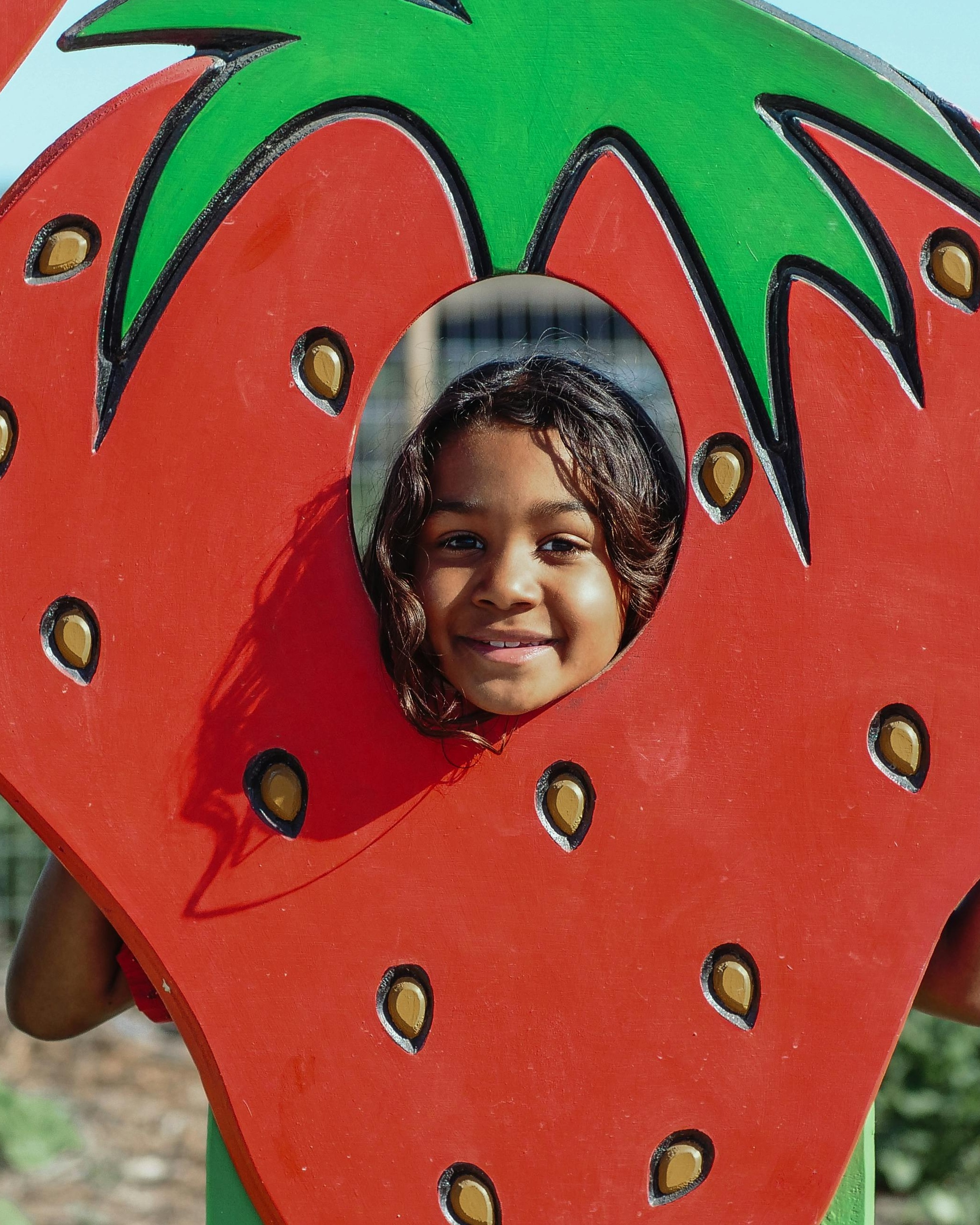 Girl Smiling Through Strawberry Photo Cutout