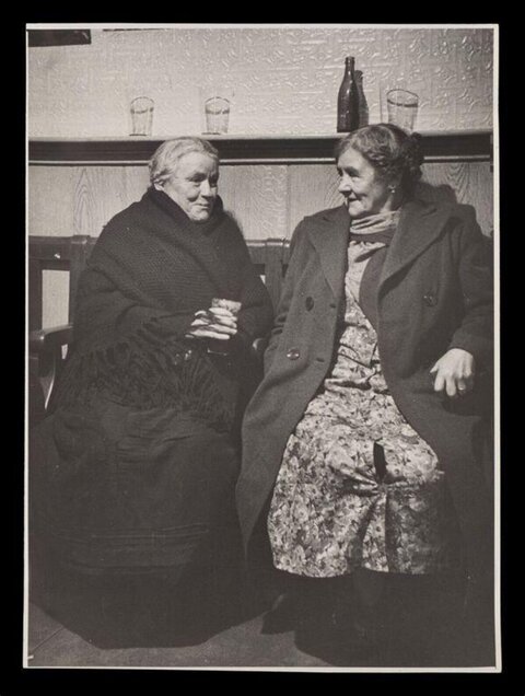 Two Elderly Women Chatting Indoors