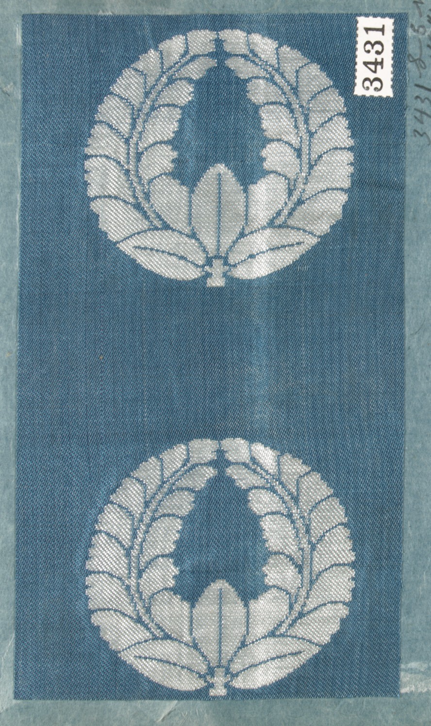 Two Silver Woven Laurel Emblems on Blue Fabric