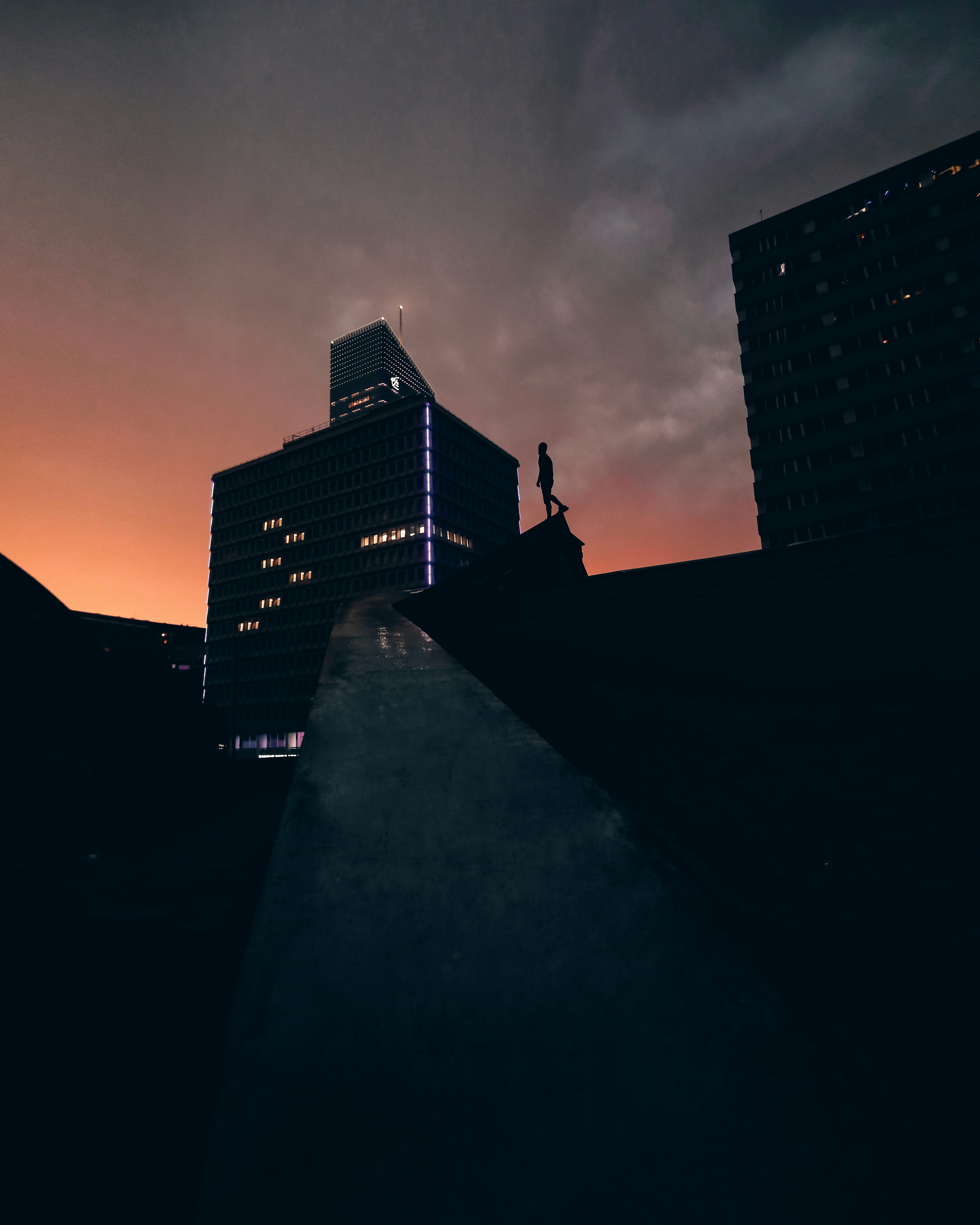 Silhouette Walker on Urban Rooftop at Dusk