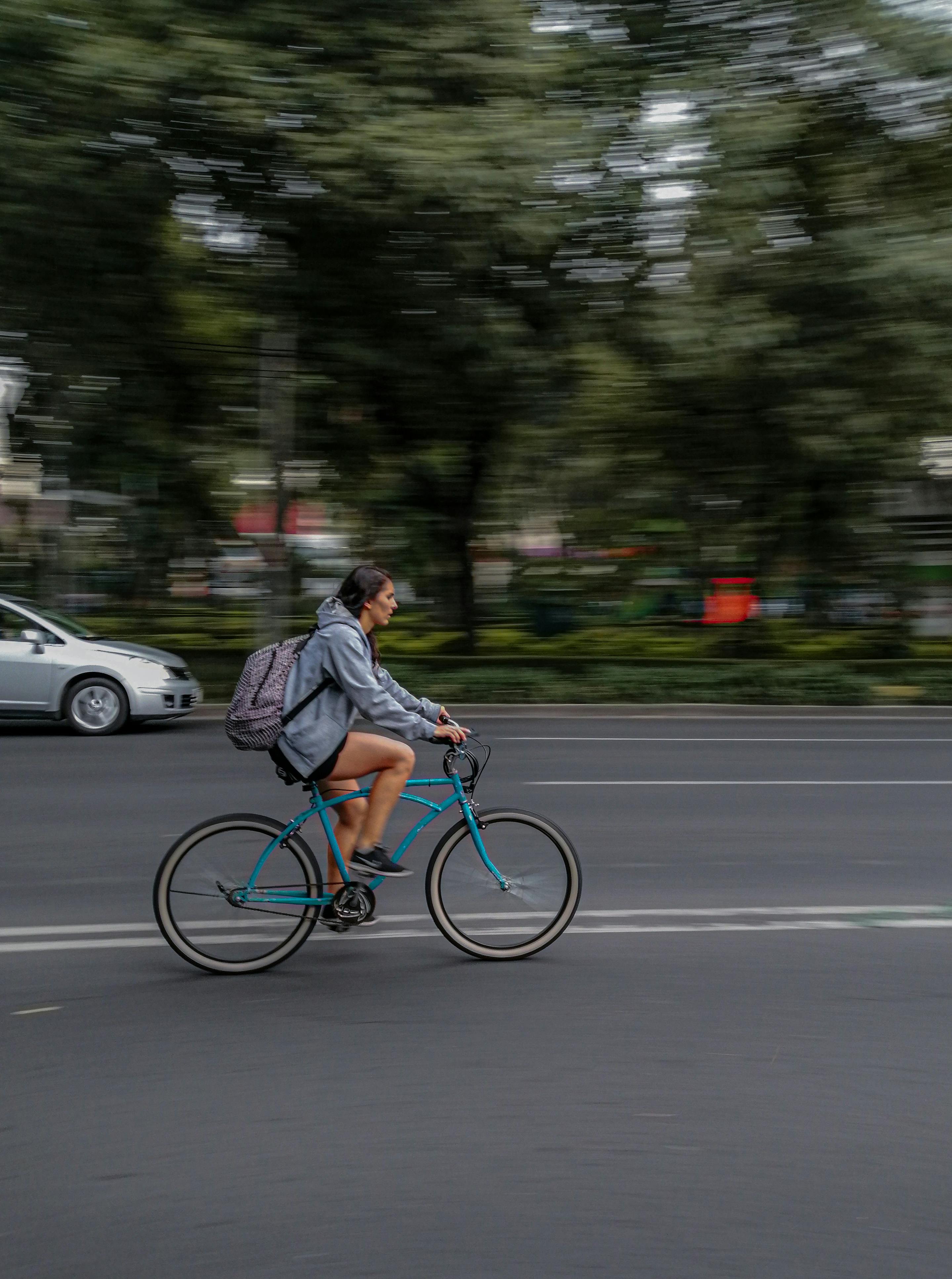 Woman Cycling on Urban Road