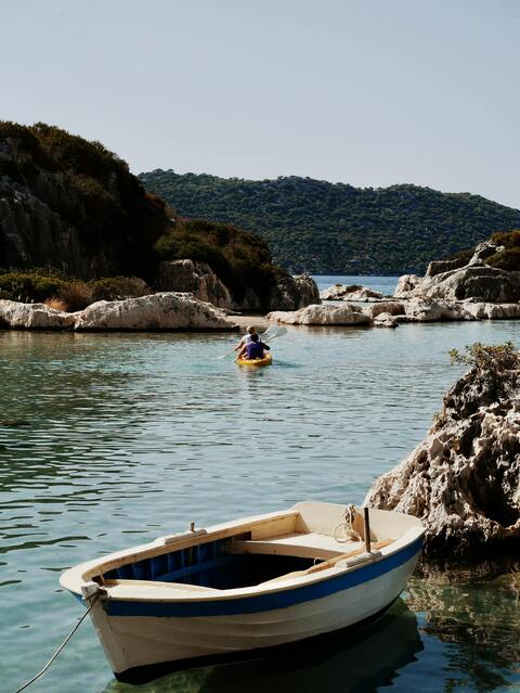 Coastal Cove with Kayakers and Moored Boat