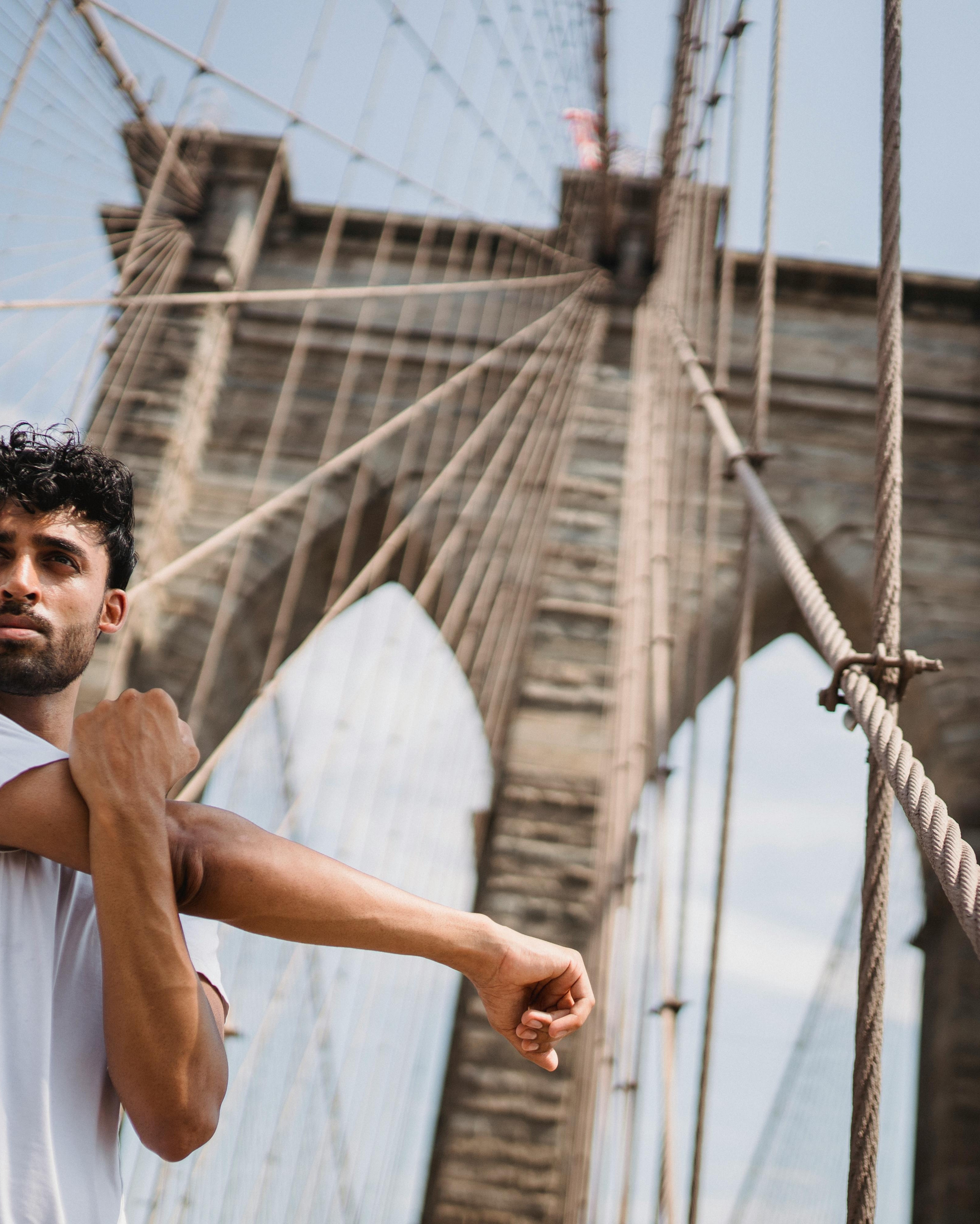 Man Stretching on Brooklyn Bridge