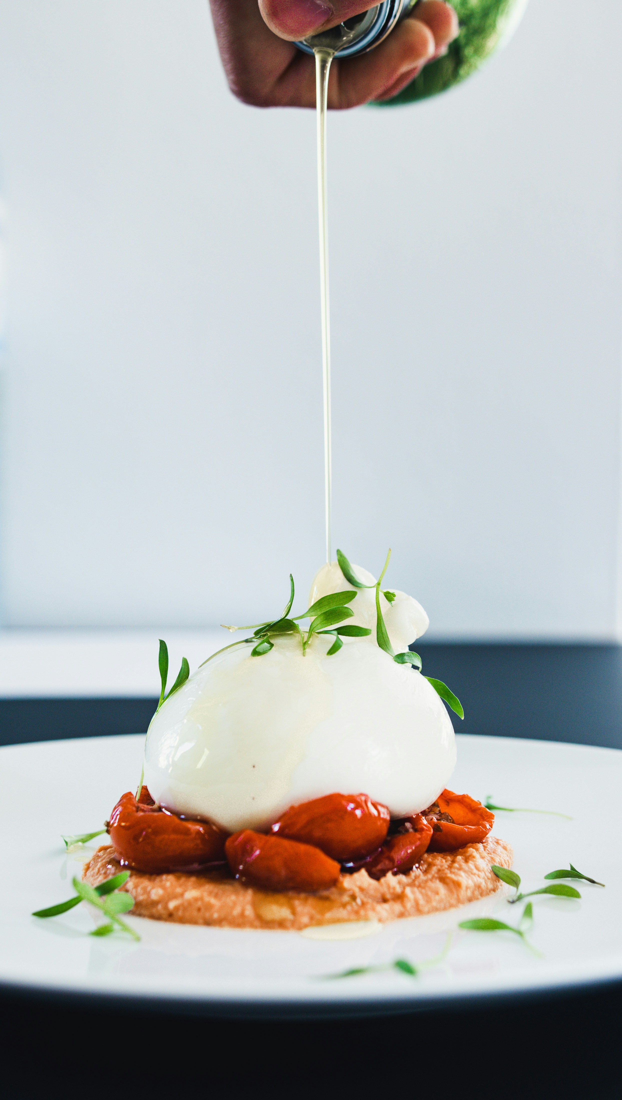 Pouring Oil Over Burrata Cheese Dish