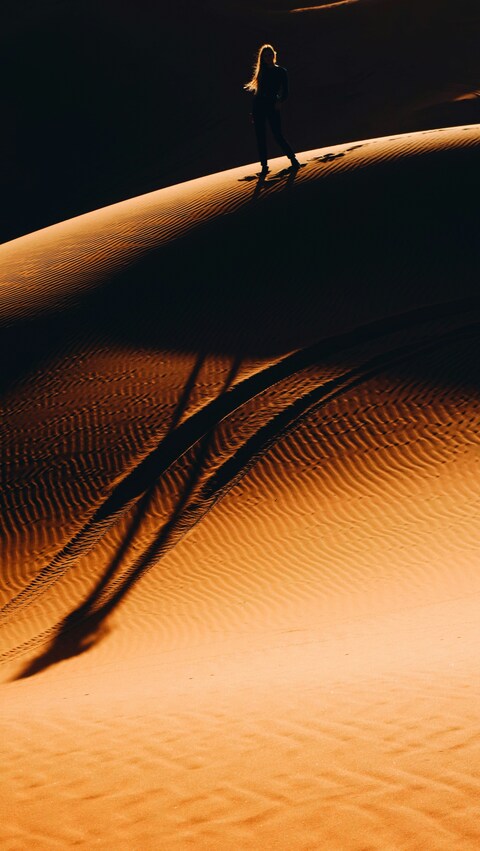 Woman Standing on Desert Sand Dune