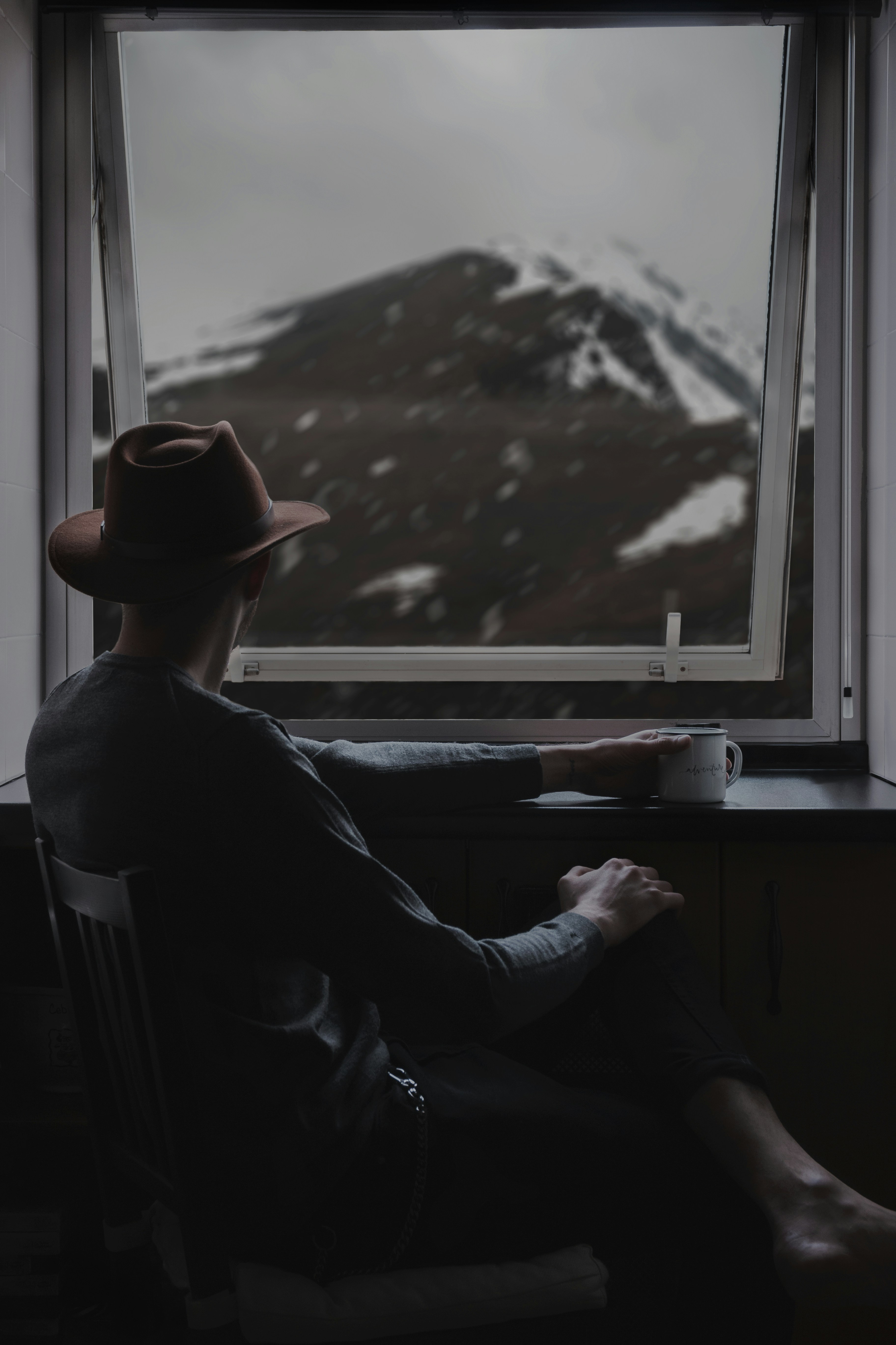 Man Watching Snow Mountain By Window
