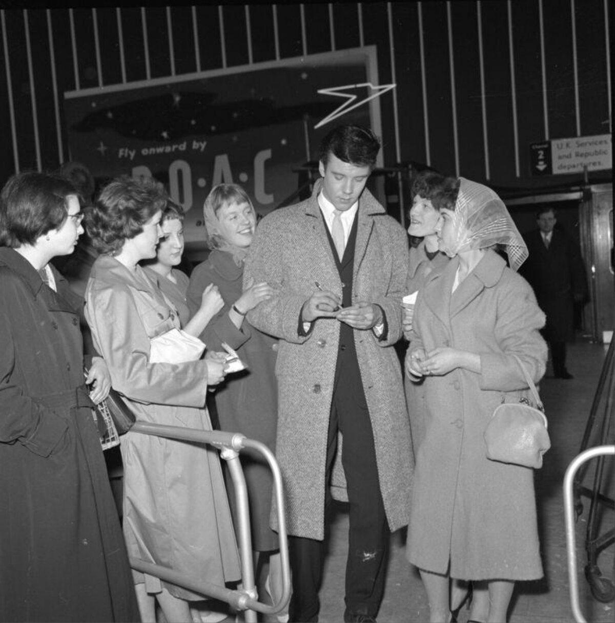 Celebrity Signs Autographs for Fans at Airport