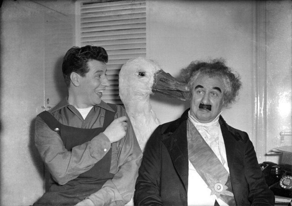 Two men with giant goose prop backstage